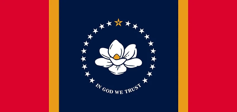The flag features a white magnolia flower on a dark blue field, encircled by stars. A gold star tops the circle, with "In God We Trust" below. Bold red and gold stripes flank the sides.