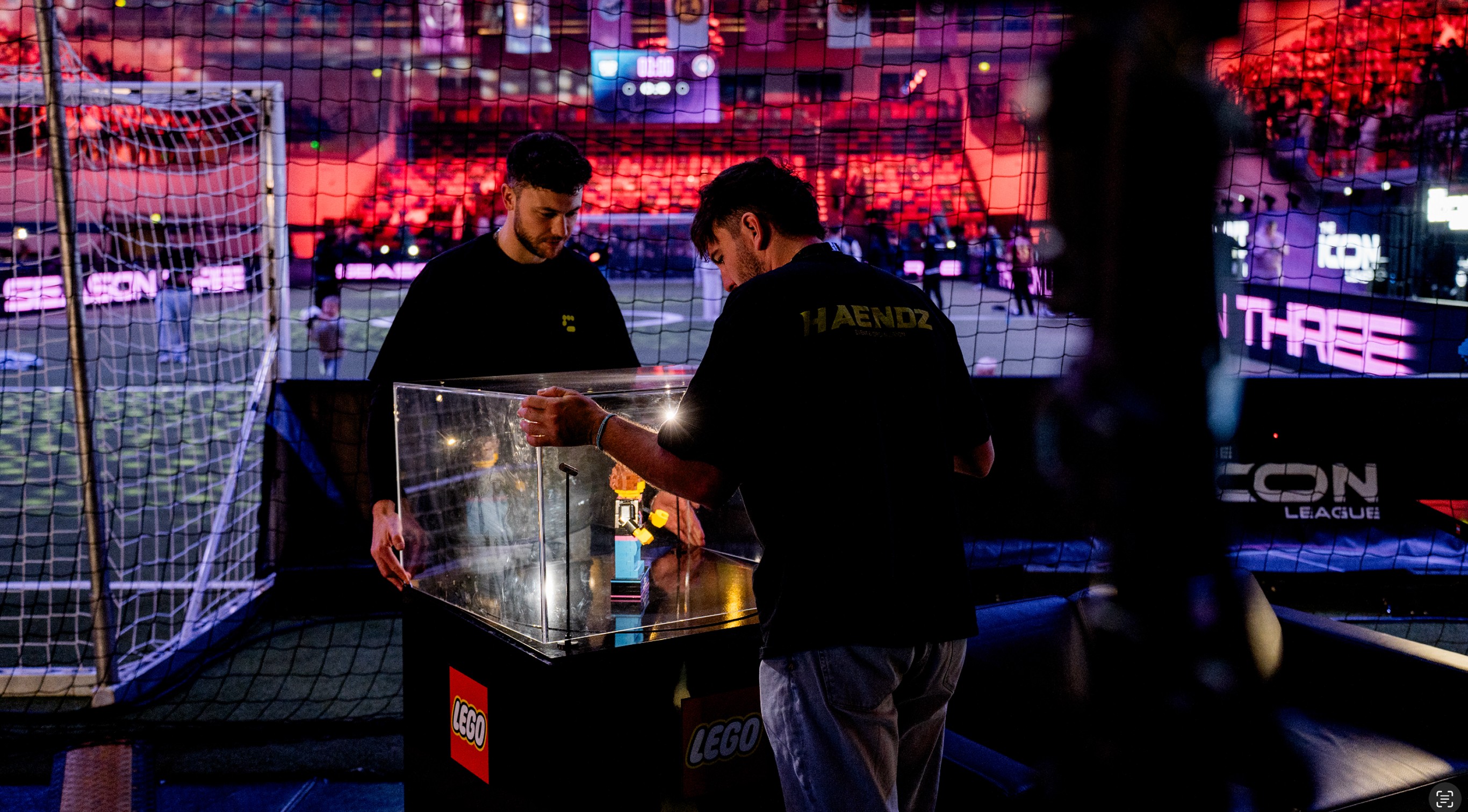 Zwei Eventmitarbeiter arbeiten an einer technischen Box hinter den Kulissen.