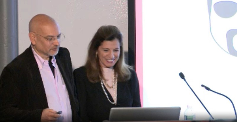 A photo of a man and a woman giving a lecture from a laptop.