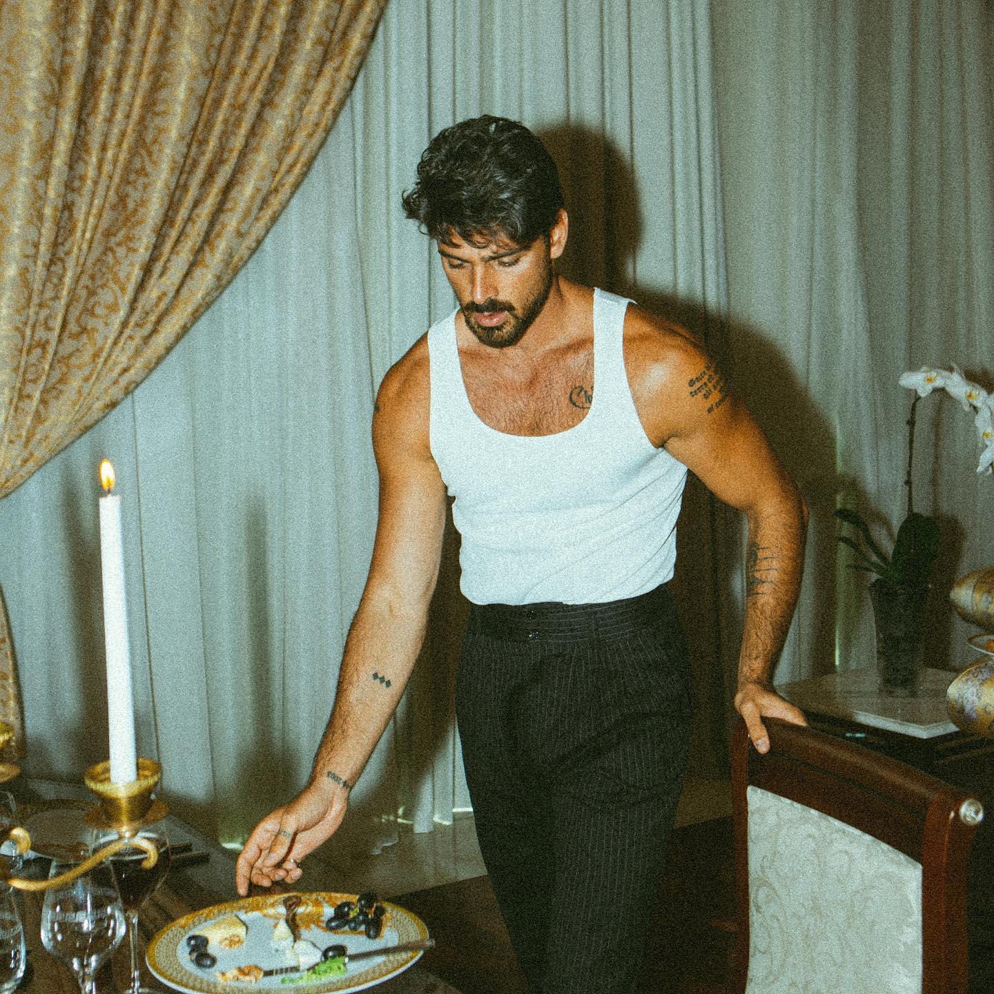 Black-and-white party photo of a smiling man in a check blazer among a crowd.