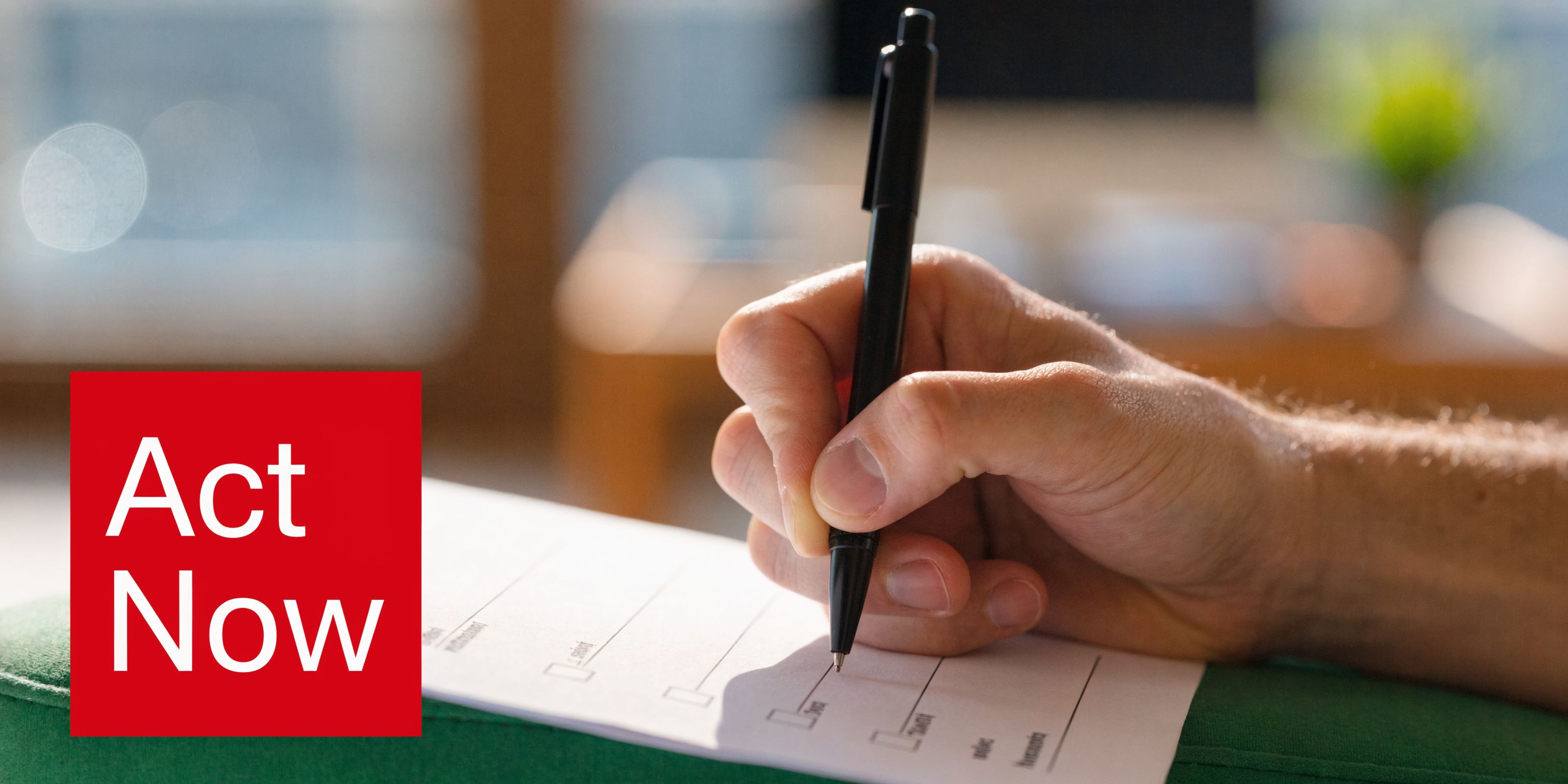 A close-up of a person's hand filling out a legal document with a black pen.