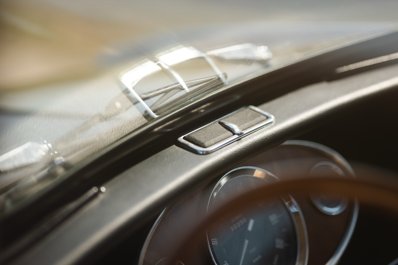 Close-up of a car dashboard showing details of the speedometer and polished wood trim.