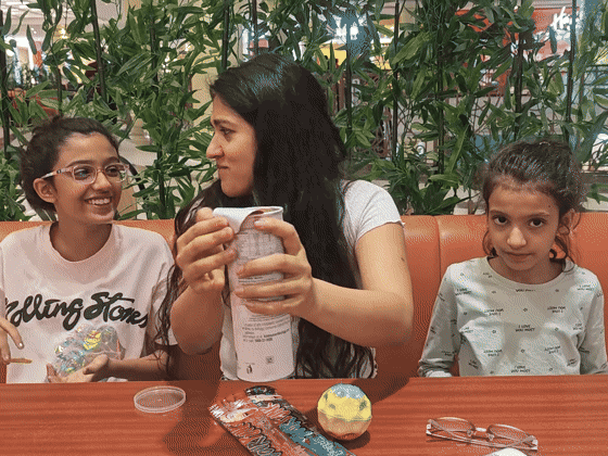 Three people share an easy laugh around an outdoor snack table