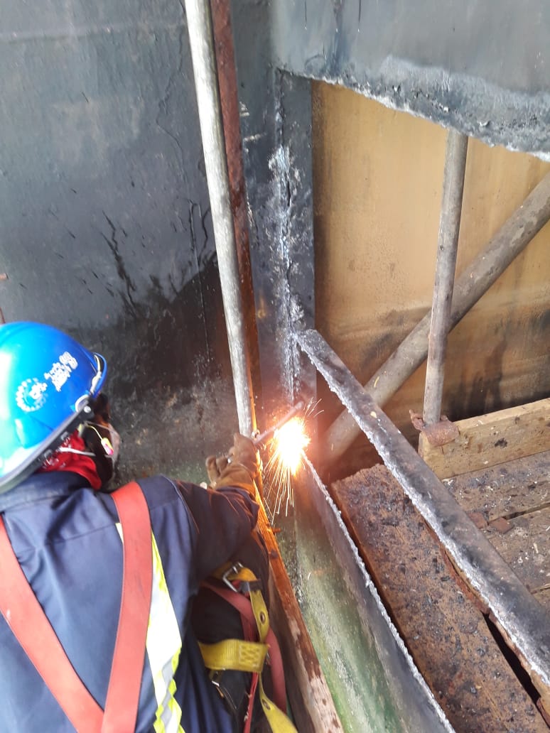 A sleek phone, likely an iPhone 16 Pro, is displayed at an angle between dark rock formations. The screen shows a futuristic design and download promo