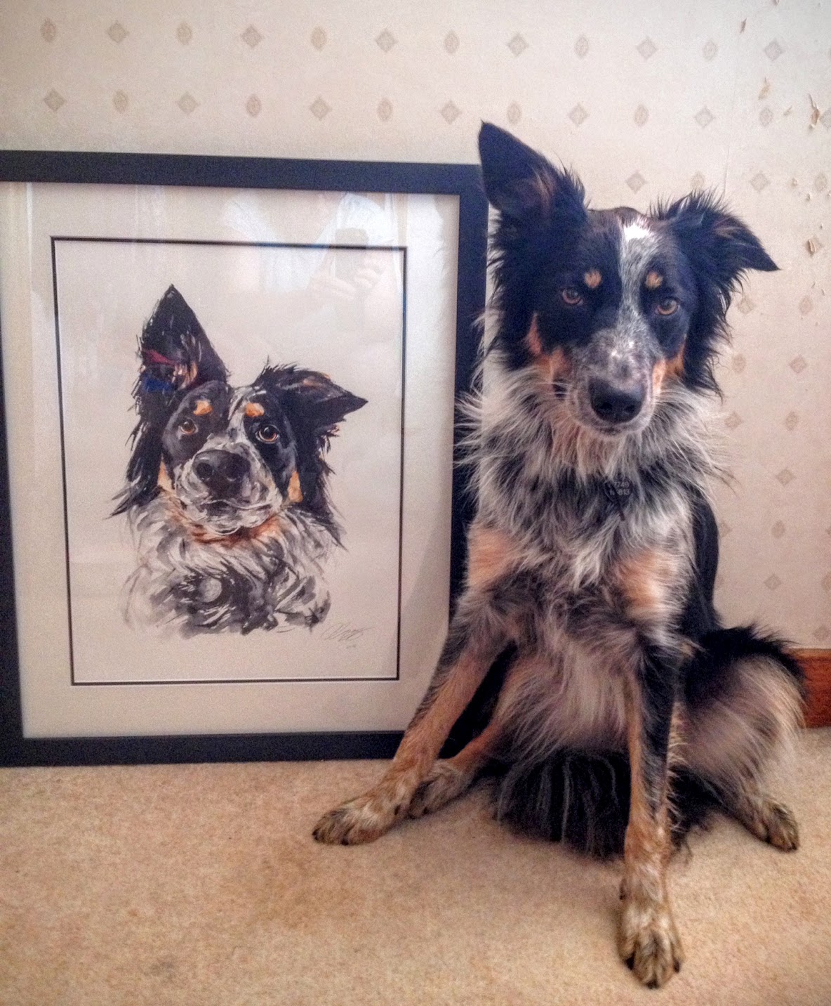Picture of dog sat next to a painting of itself