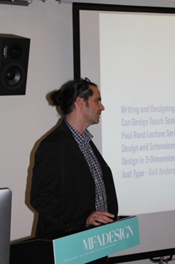 a man giving a speech with a image projected on a wall with a paragraph