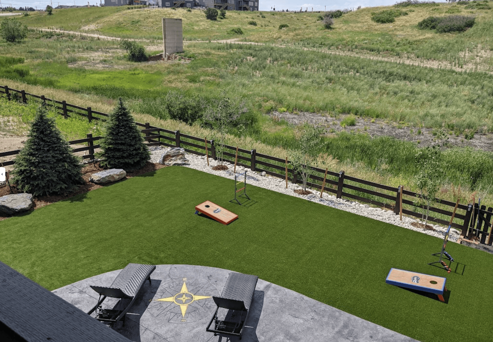 beautiful artificial grass installation on the patio of an aerial view of a luxury home in Colorado, featuring two chairs and a table