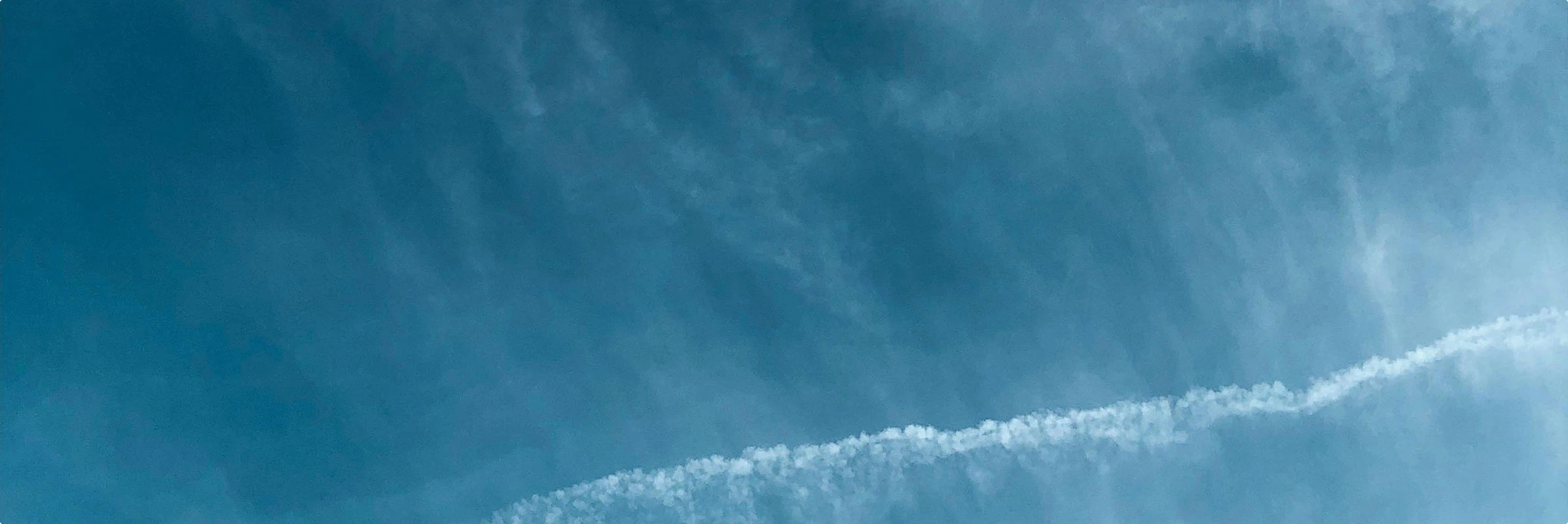 Abstract pattern of wispy white clouds against a blue sky
