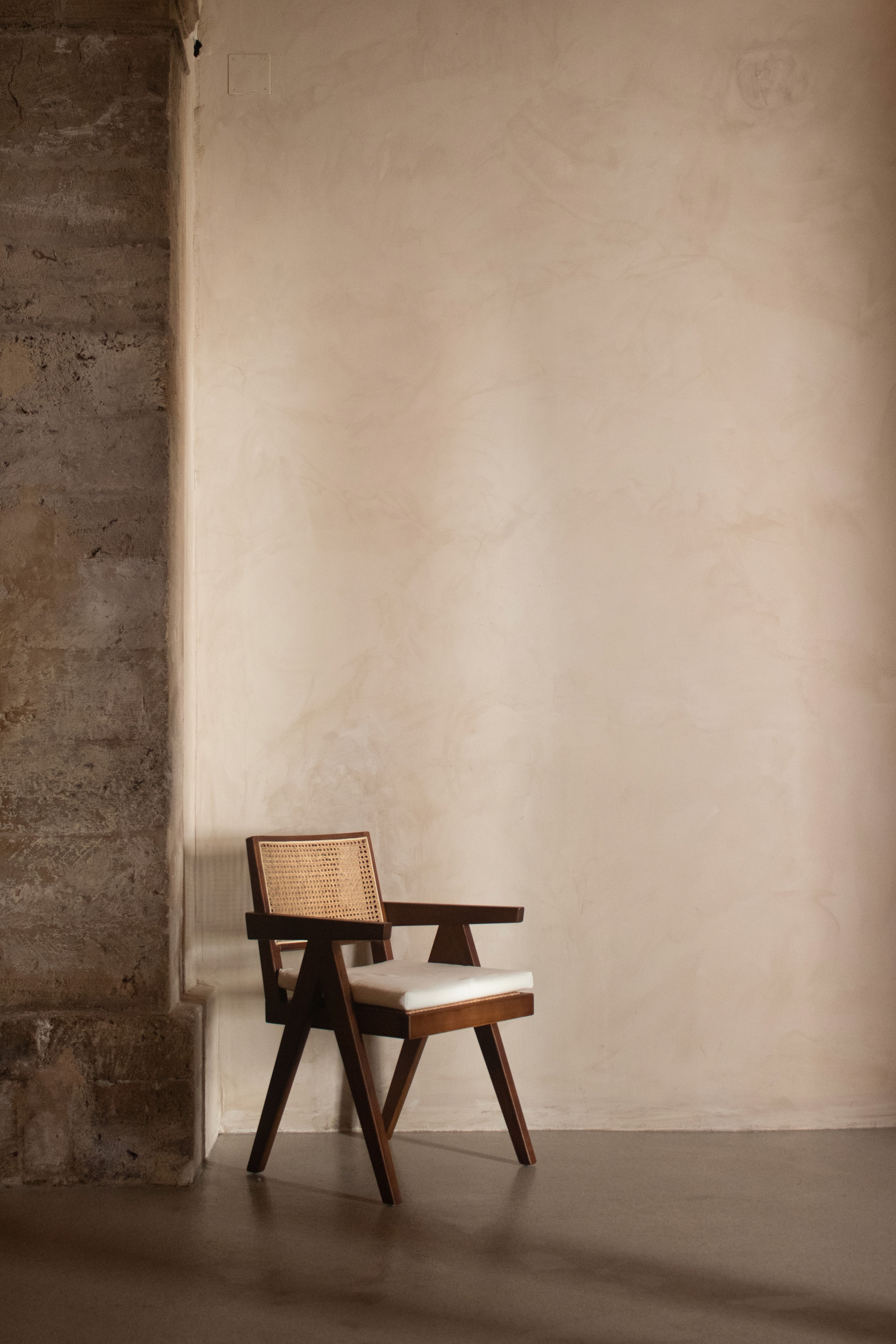 Wooden chair against textured plaster wall