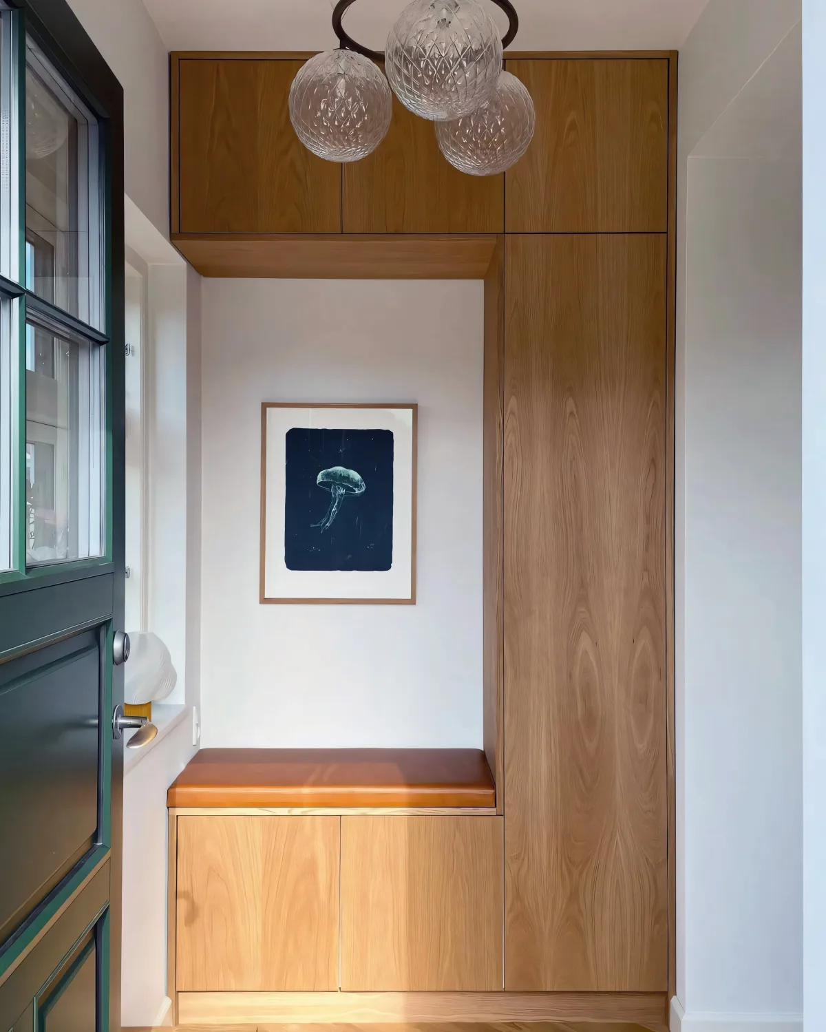 Aménagement d'une entrée avec rangements intégrés sur mesure en chêne, banquette et suspensions en verre soufflé, décoration intérieure épurée