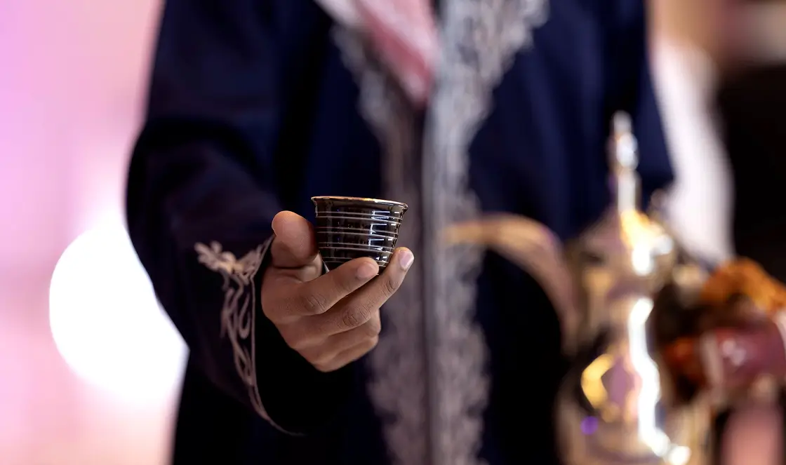 Man offering a welcome drink to an event visitor