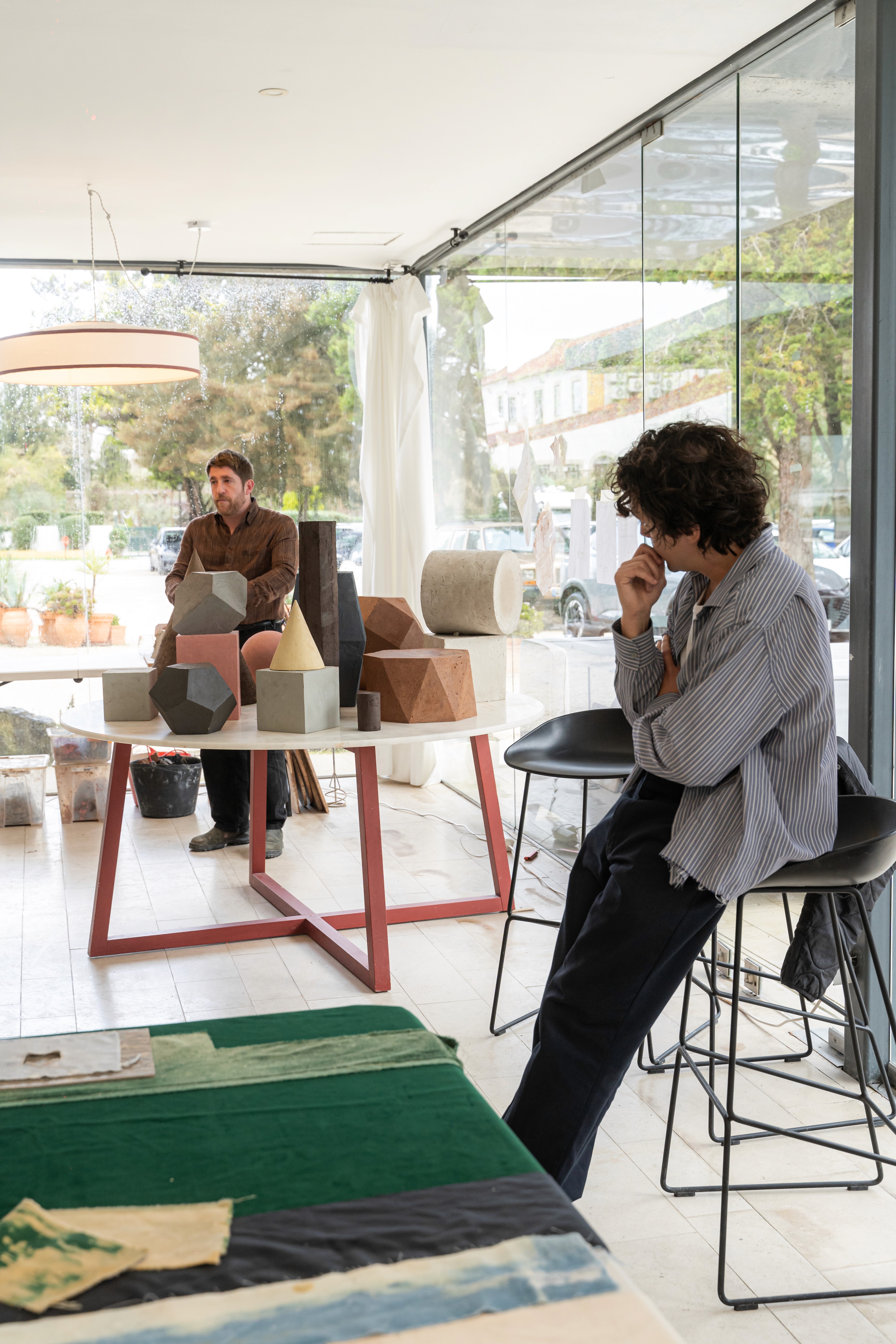 Residency studio discussion with sculptural materials on a table