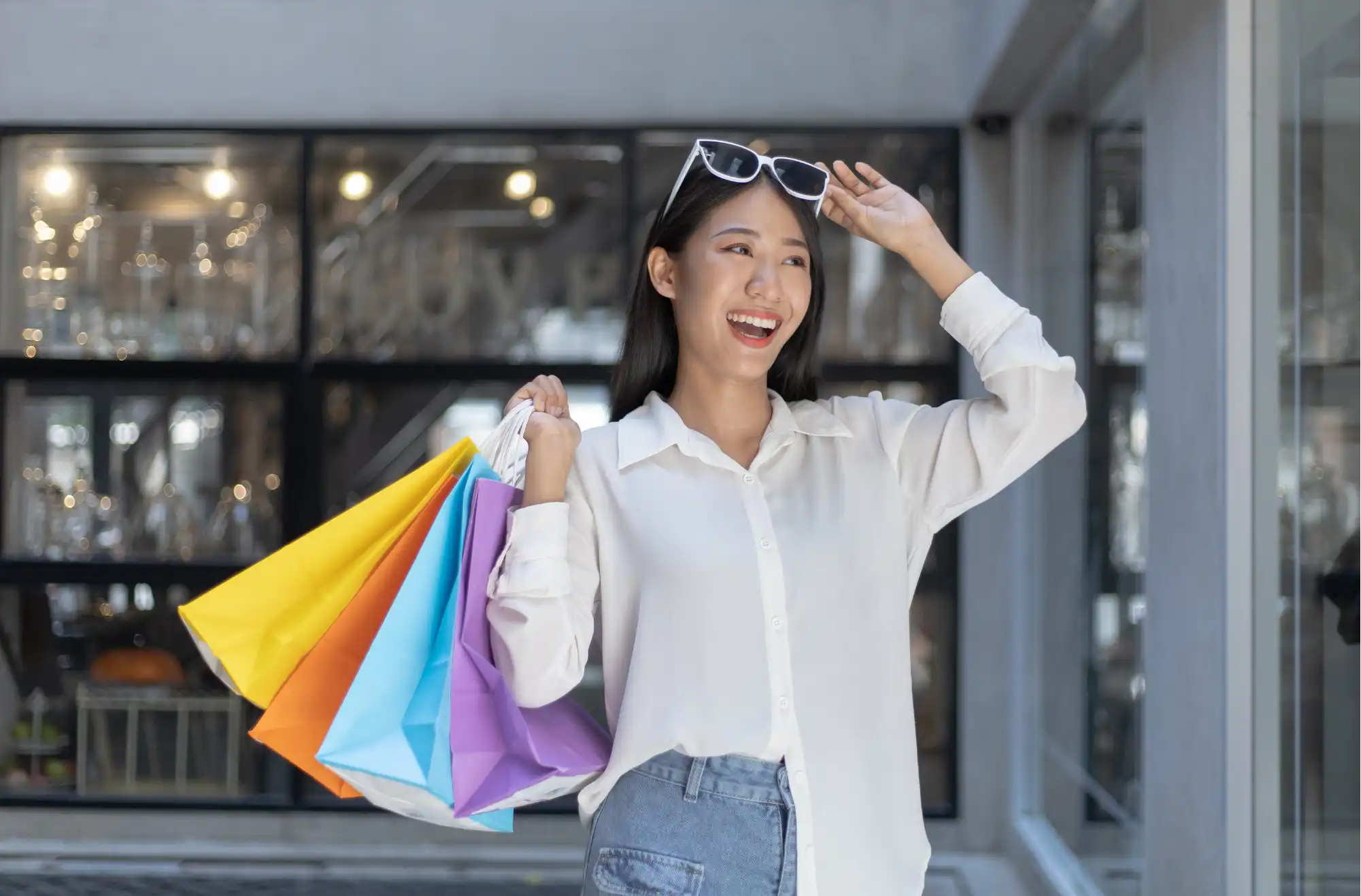 Stylish woman celebrating successful shopping with silver bags representing social commerce and influencer-driven retail experiences