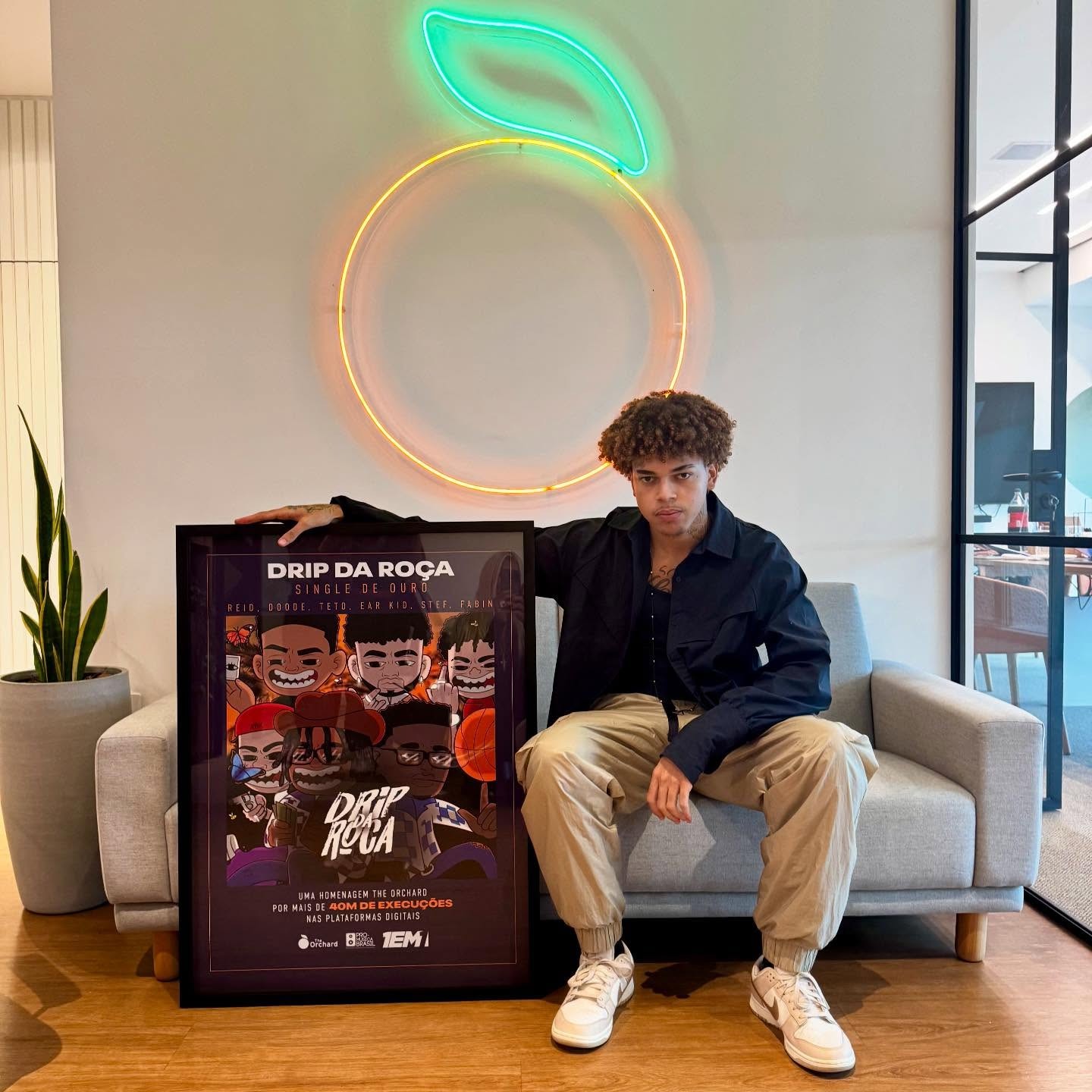 Artista Reid com uma placa de premiação por mais de 40 milhões de streamings da sua música Drip da Roça. - 1em1
