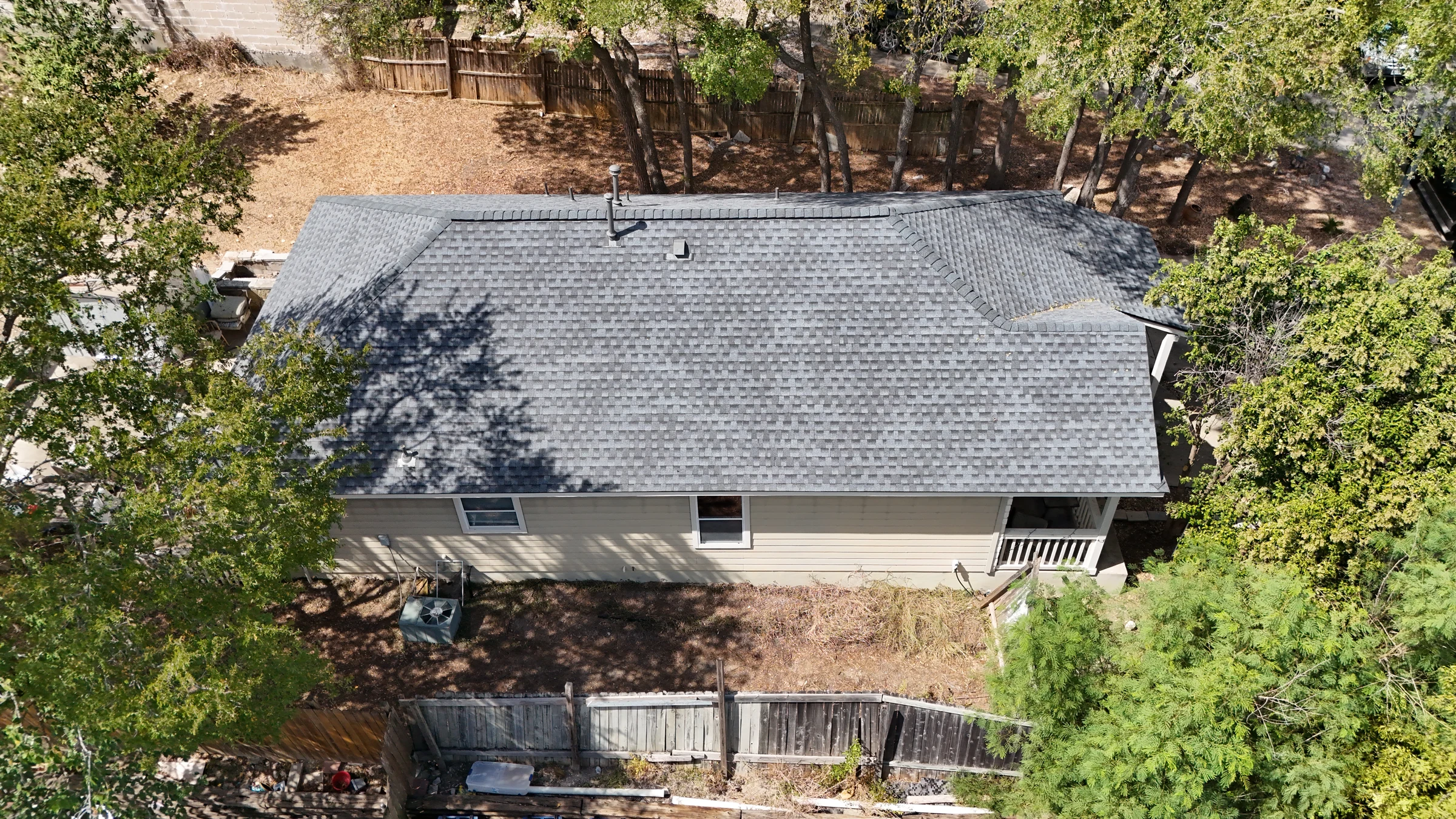 Finished Pewter Grey architectural shingle roof in Austin, viewed from the side by drone.