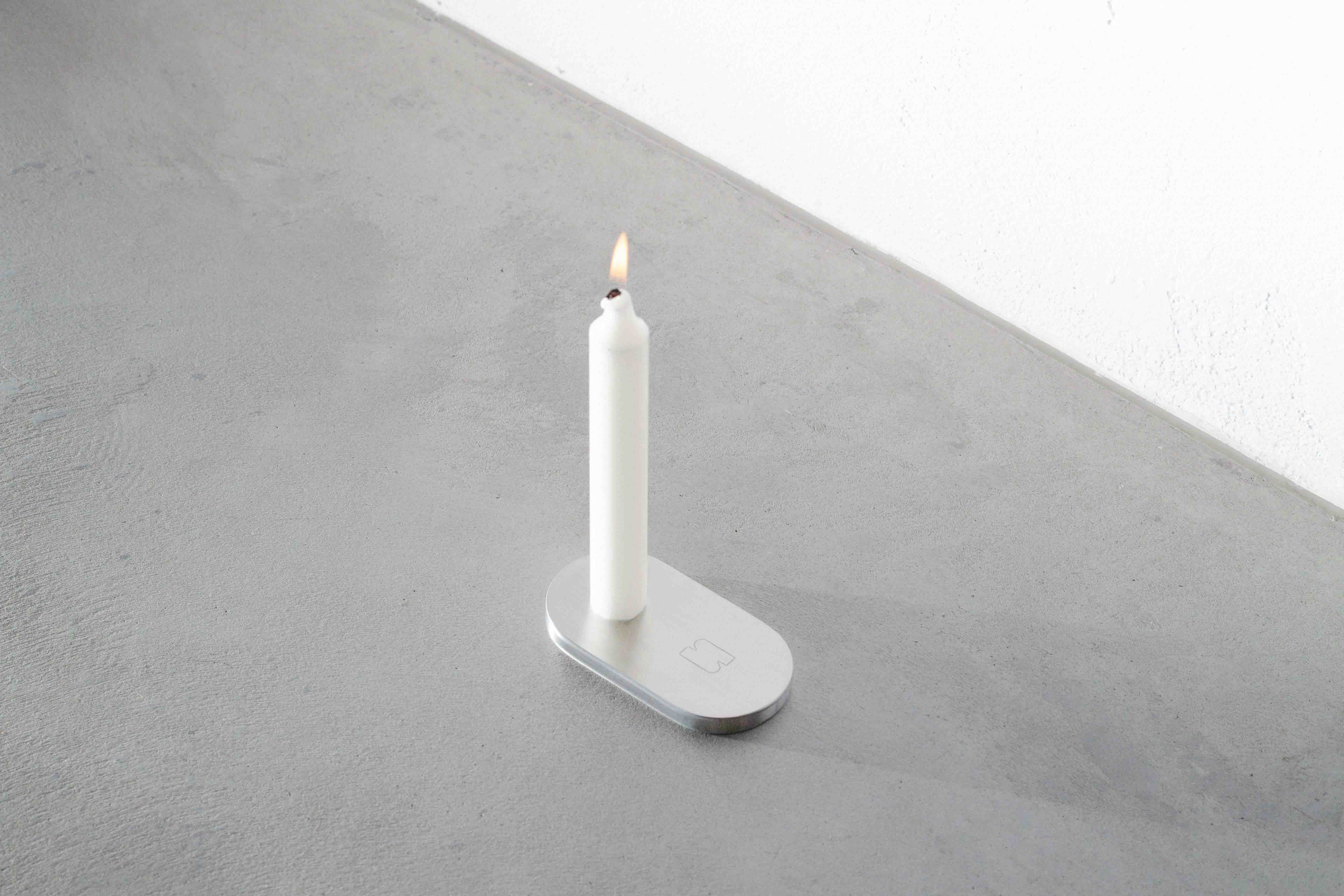 sideview of a metal candle holder on a concrete floor