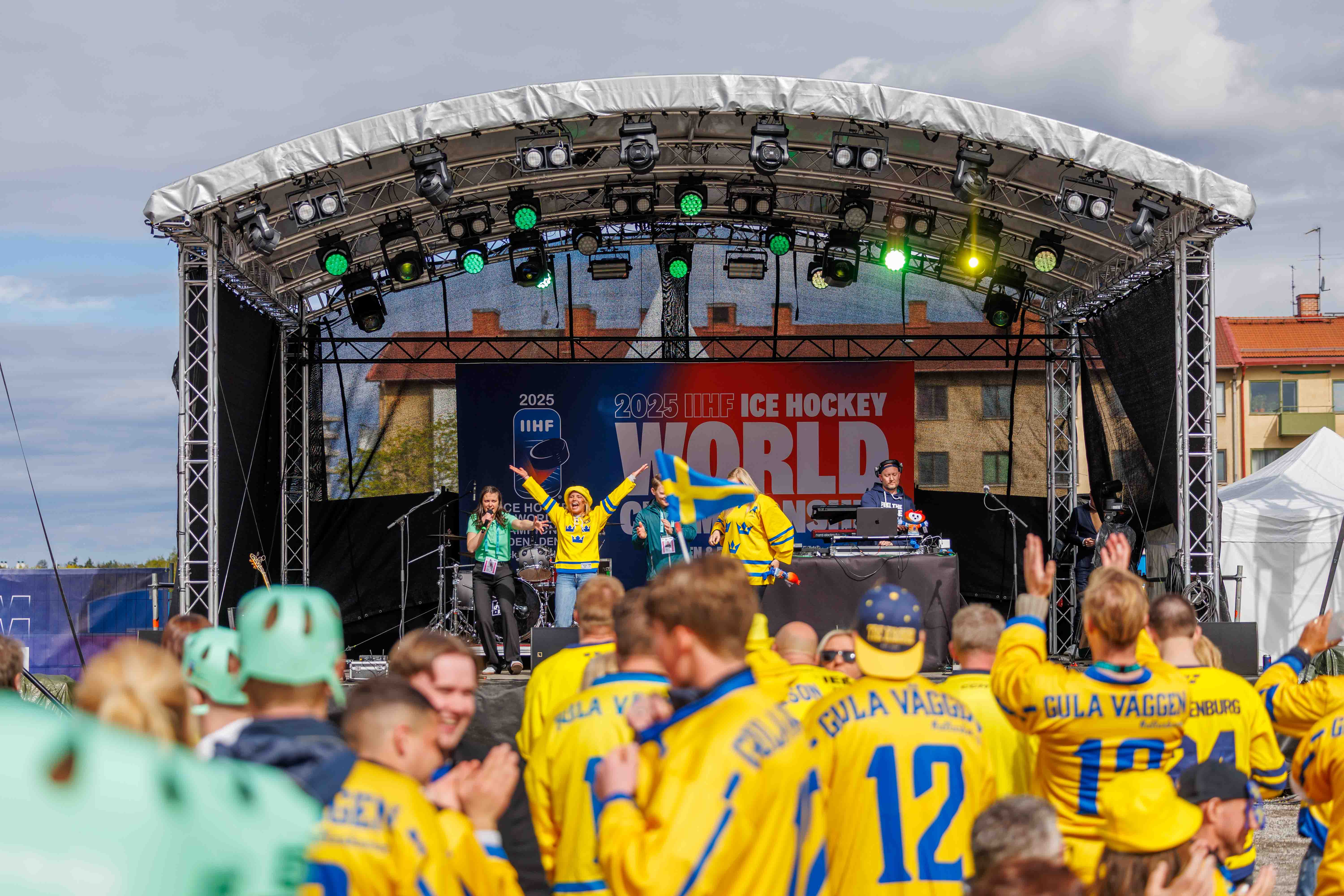Live music performance energizing fans at the 2025 IIHF World Championship outdoor stage in Stockholm.