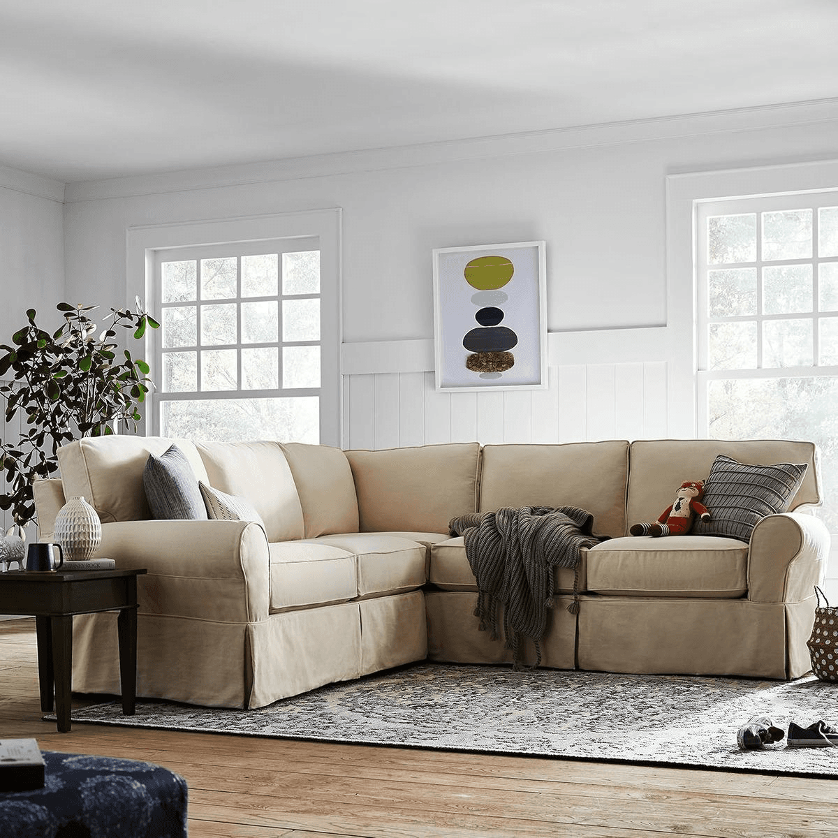 Beige Stone & Beam Carrigan modern sectional sofa in a well-lit living room with patterned rug and wall art