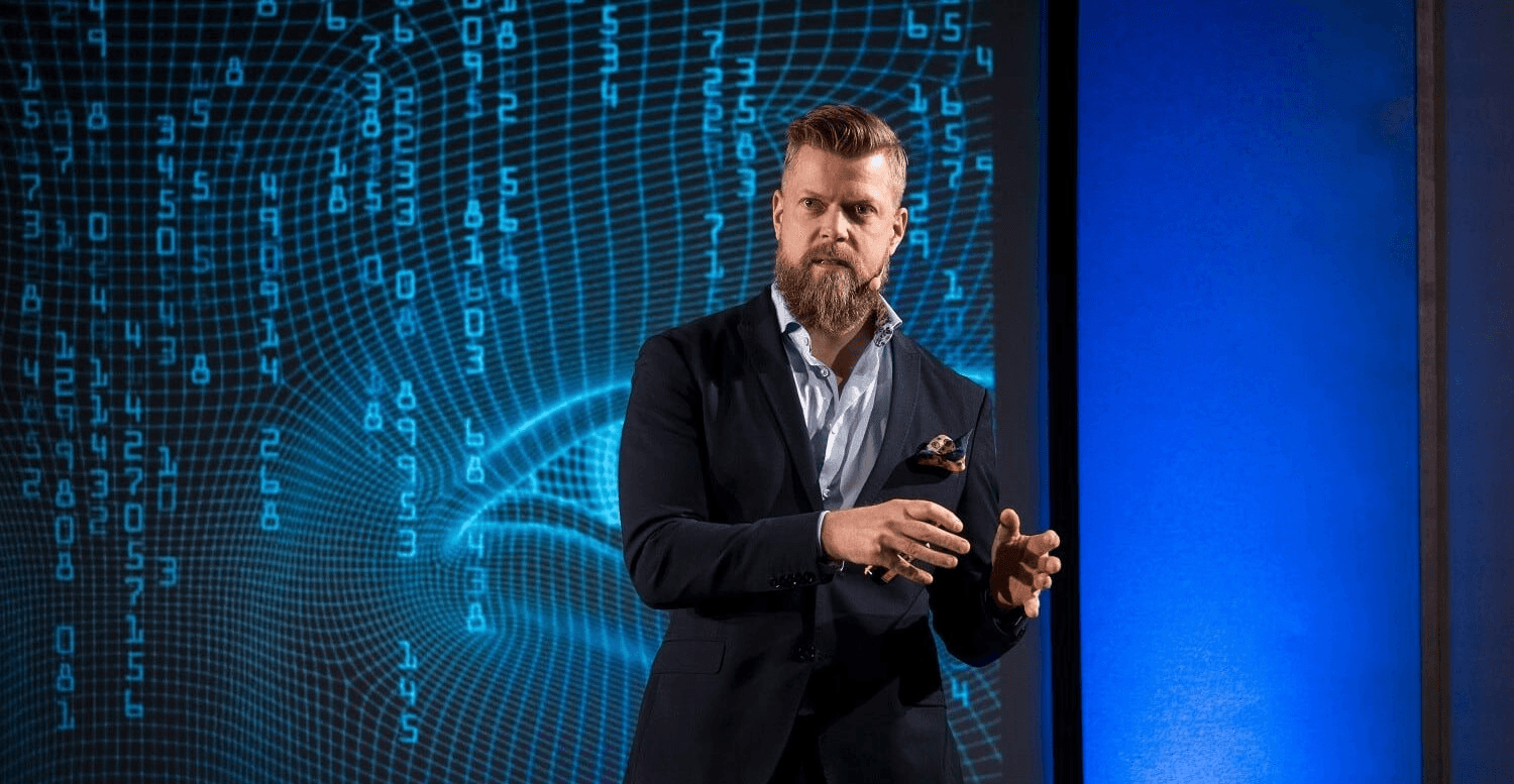 a person holding a small device in front of a laptop