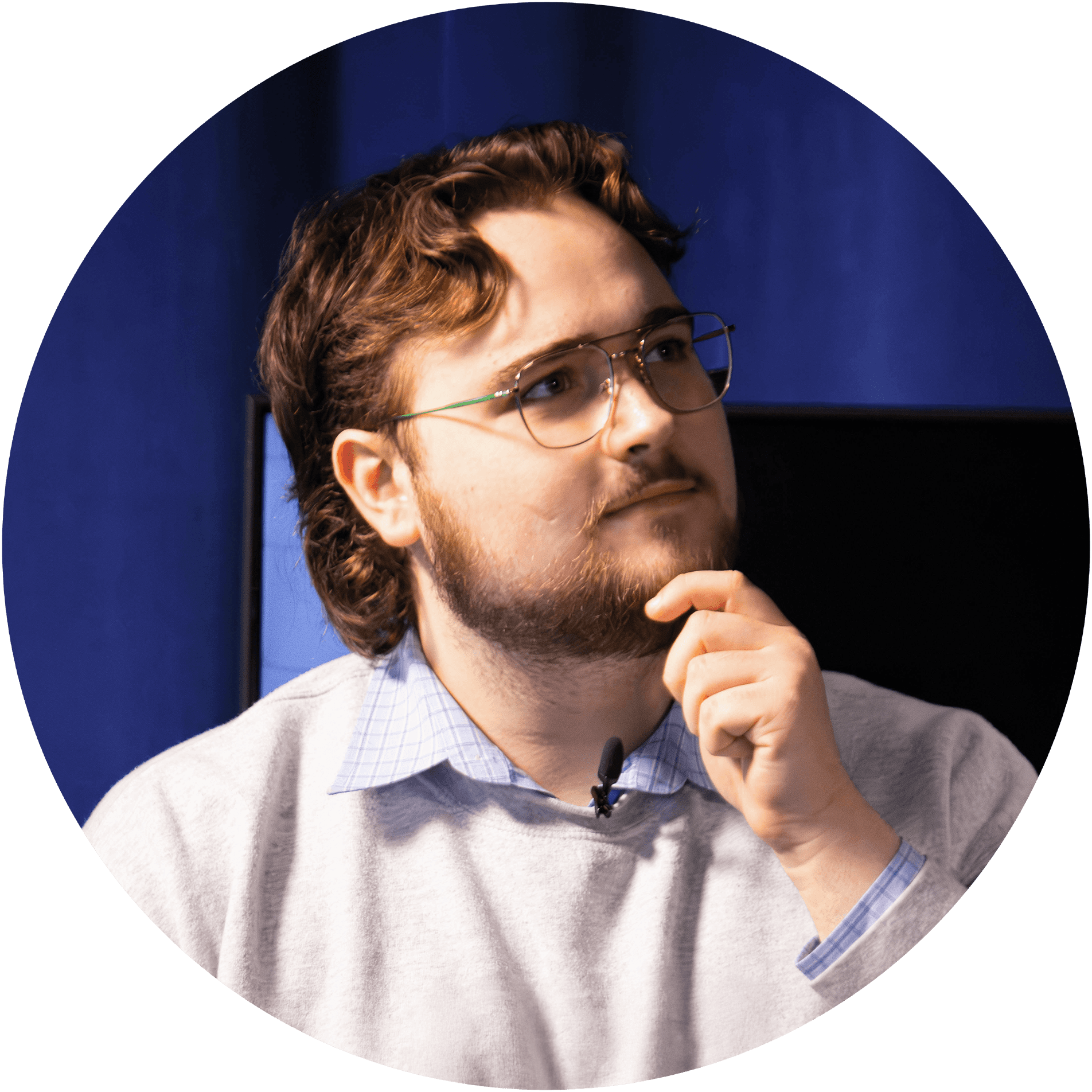 An Image of a young man with a his hand placed on his chin, deep in thought.