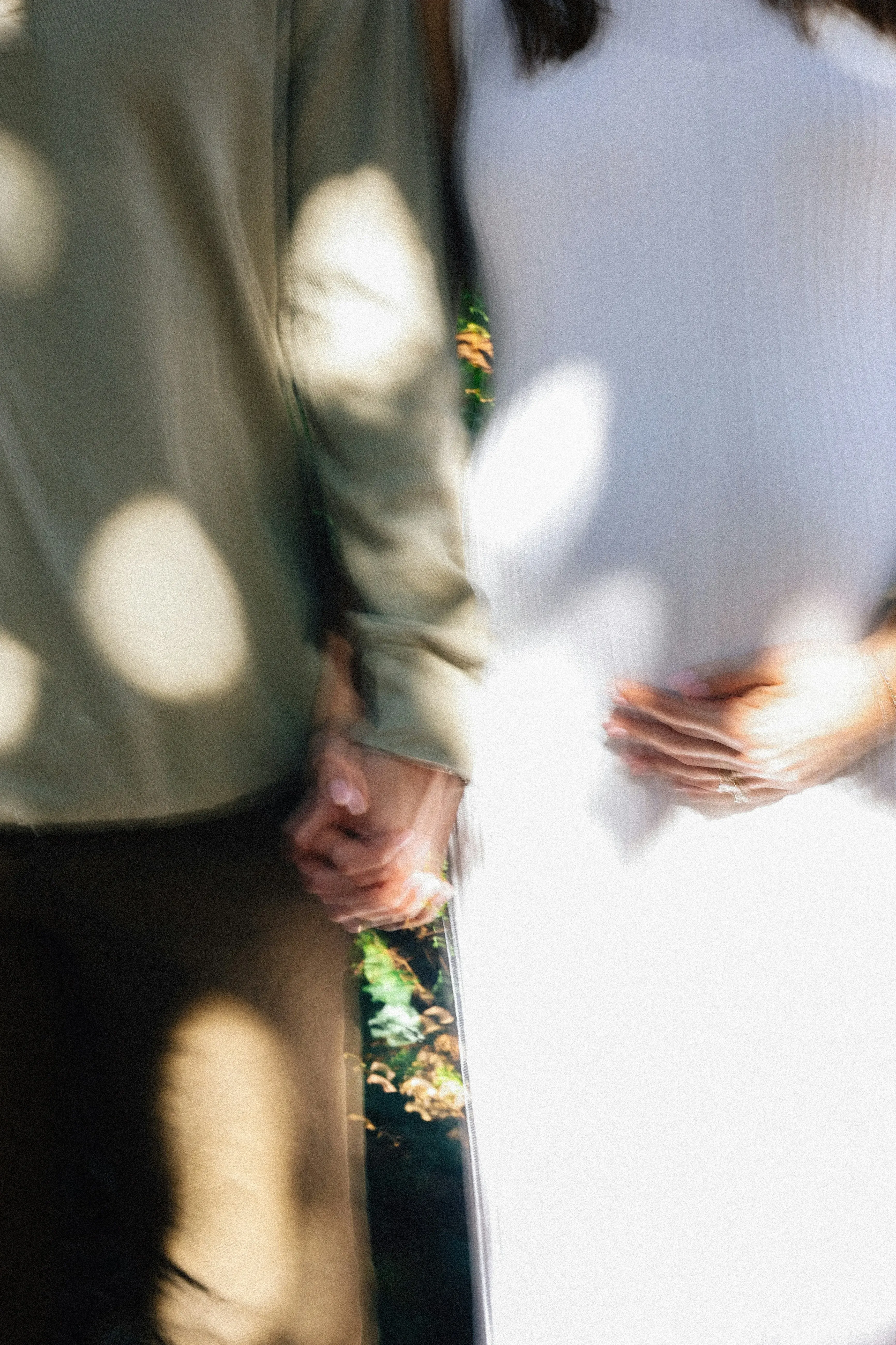 Expecting couple lovingly holding hands together.