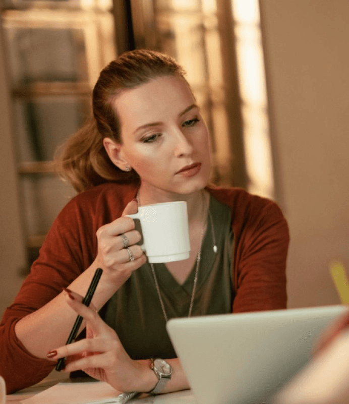 girl using laptop and drinking coffee