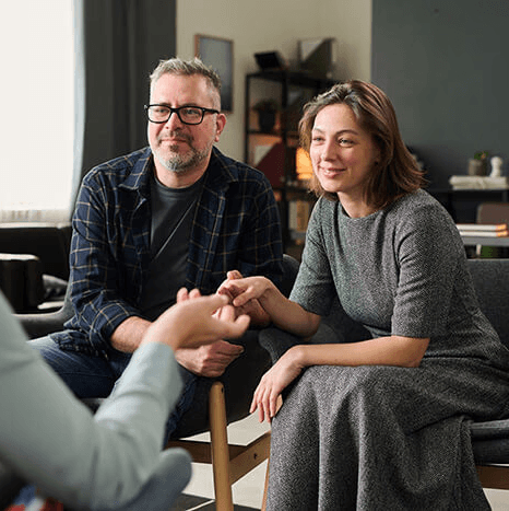 couple sitting in chair talking to a woman
