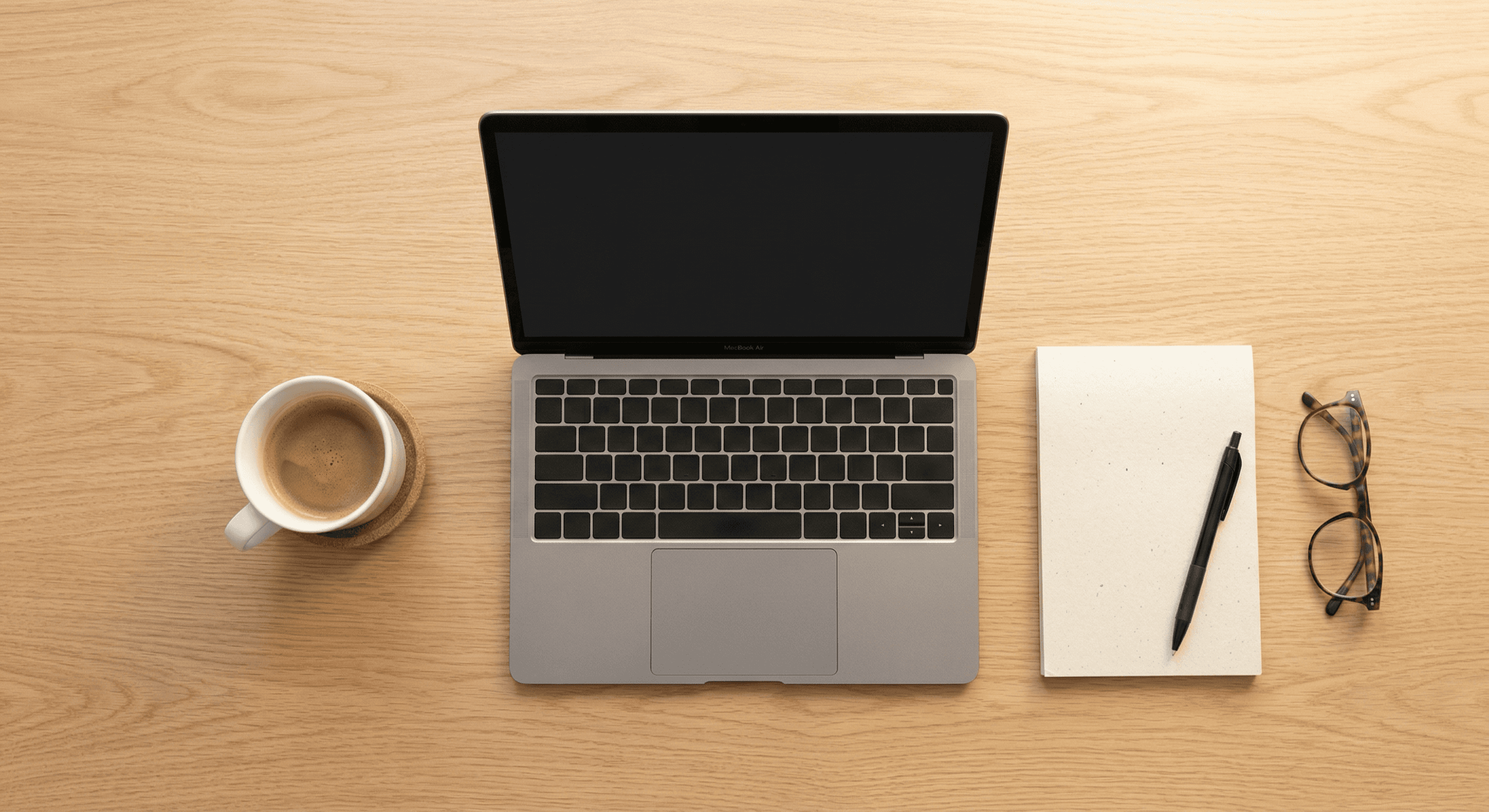 Clean desk with laptop, notepad, and reading glasses prepared for researching ADA workplace accommodation questions