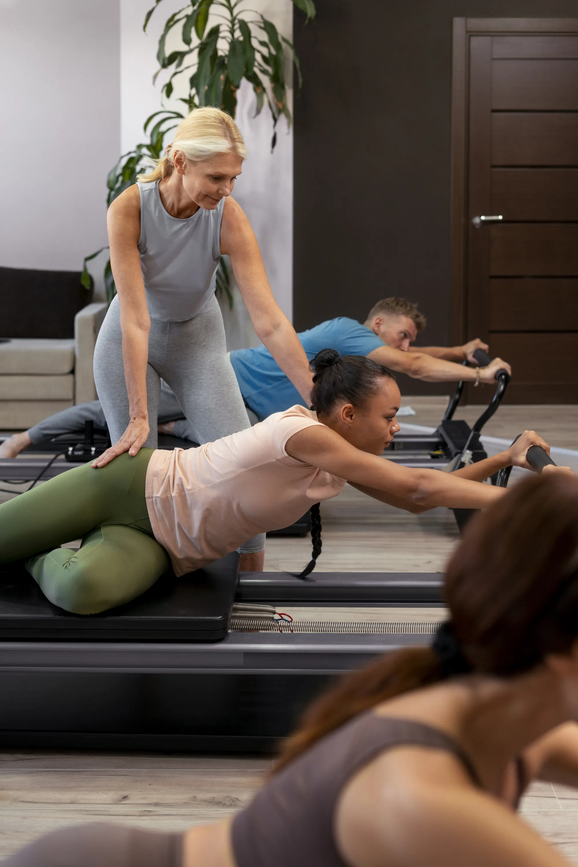 personal trainer auxiliando cliente em alongamento no chão