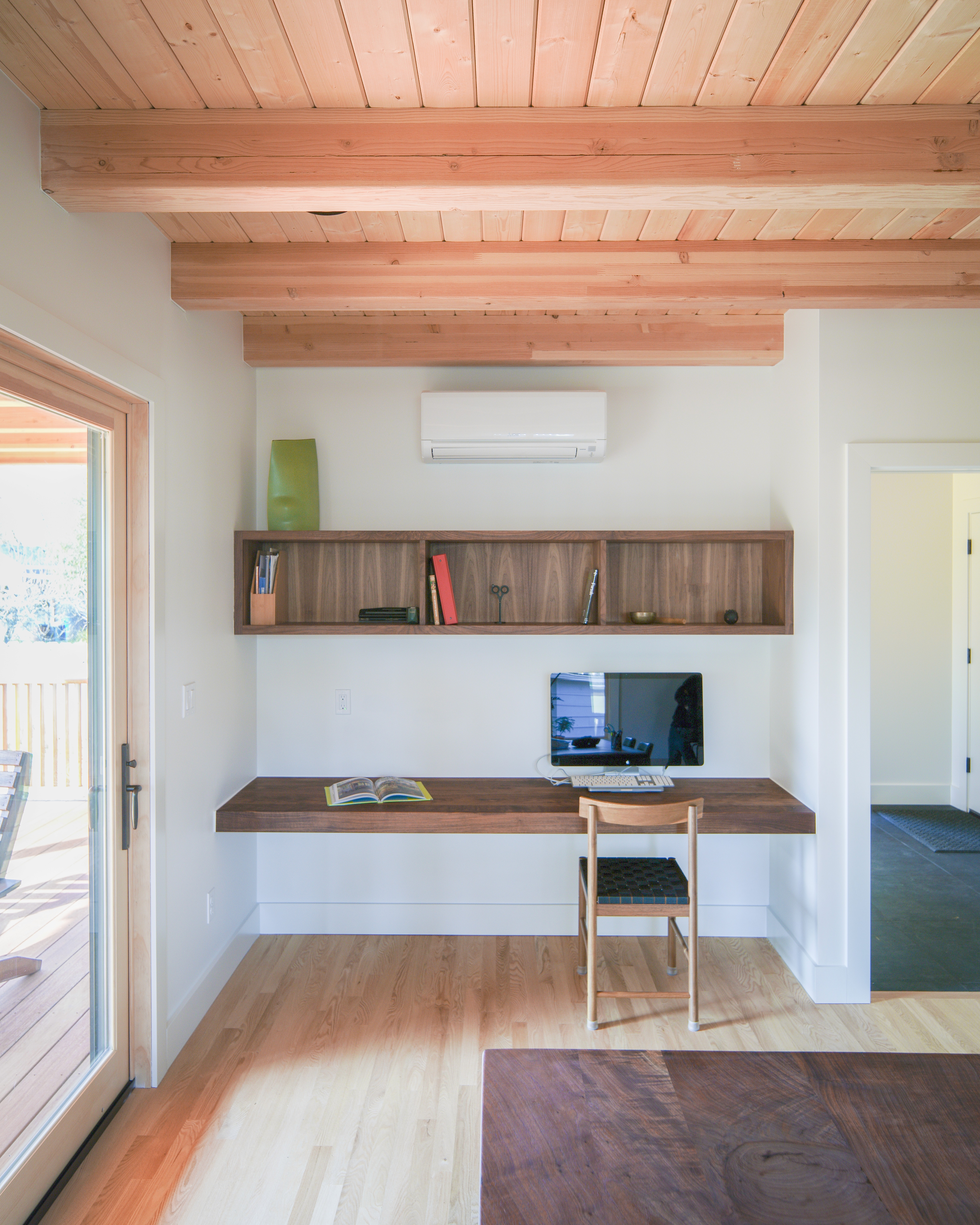 A desk and workstation nook with built-in wooden book cubby sits in a notch.