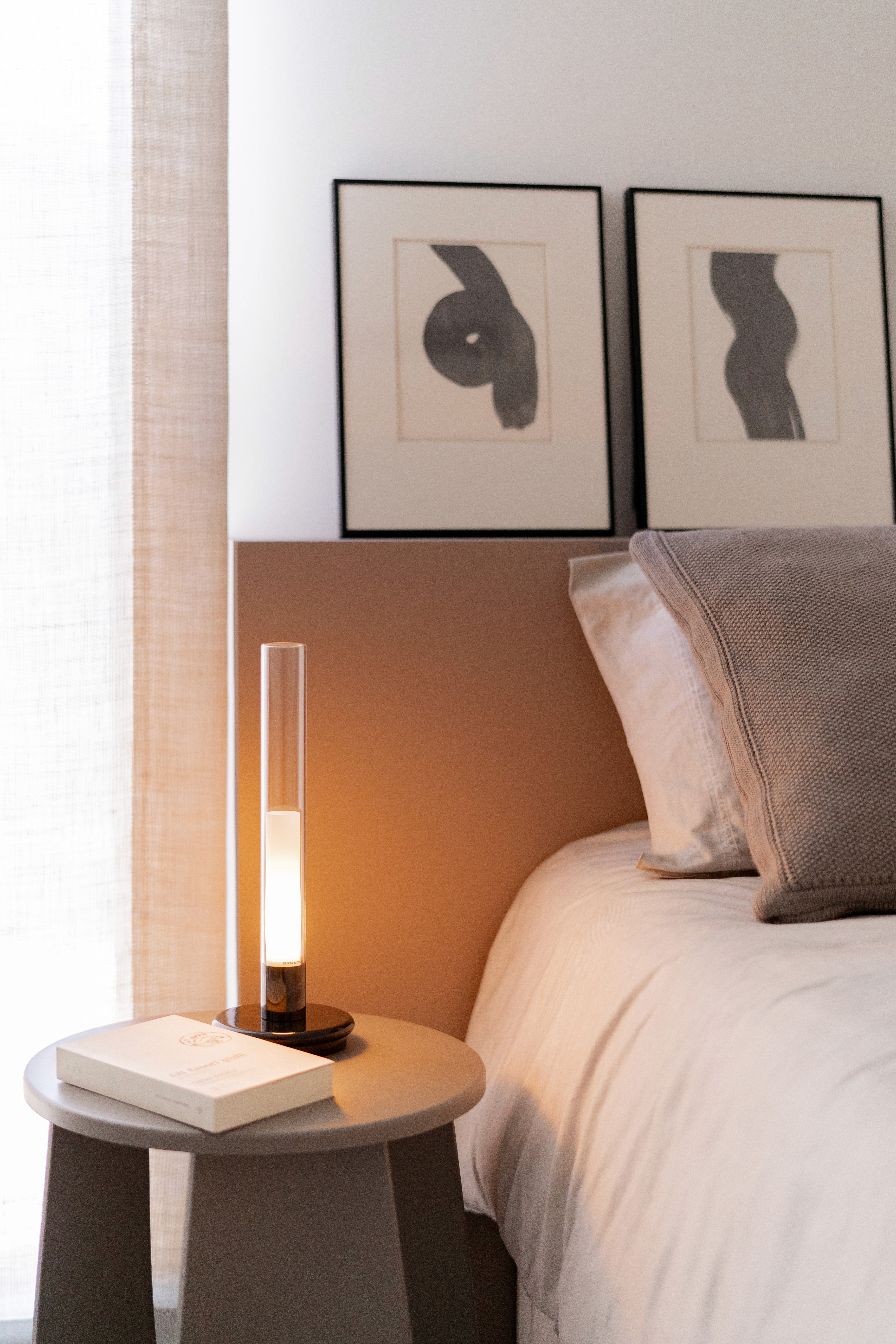 Detalle mesita de noche en dormitorio moderno con tonos neutros grises