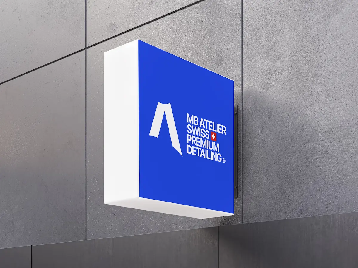 Enseigne murale MB Atelier sur façade grise en gros plan