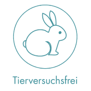 A woman lying down with a towel wrapped around her head, her face glistening with facial oil. Her eyes are closed, and she appears to be enjoying a spa treatment in a peaceful setting.