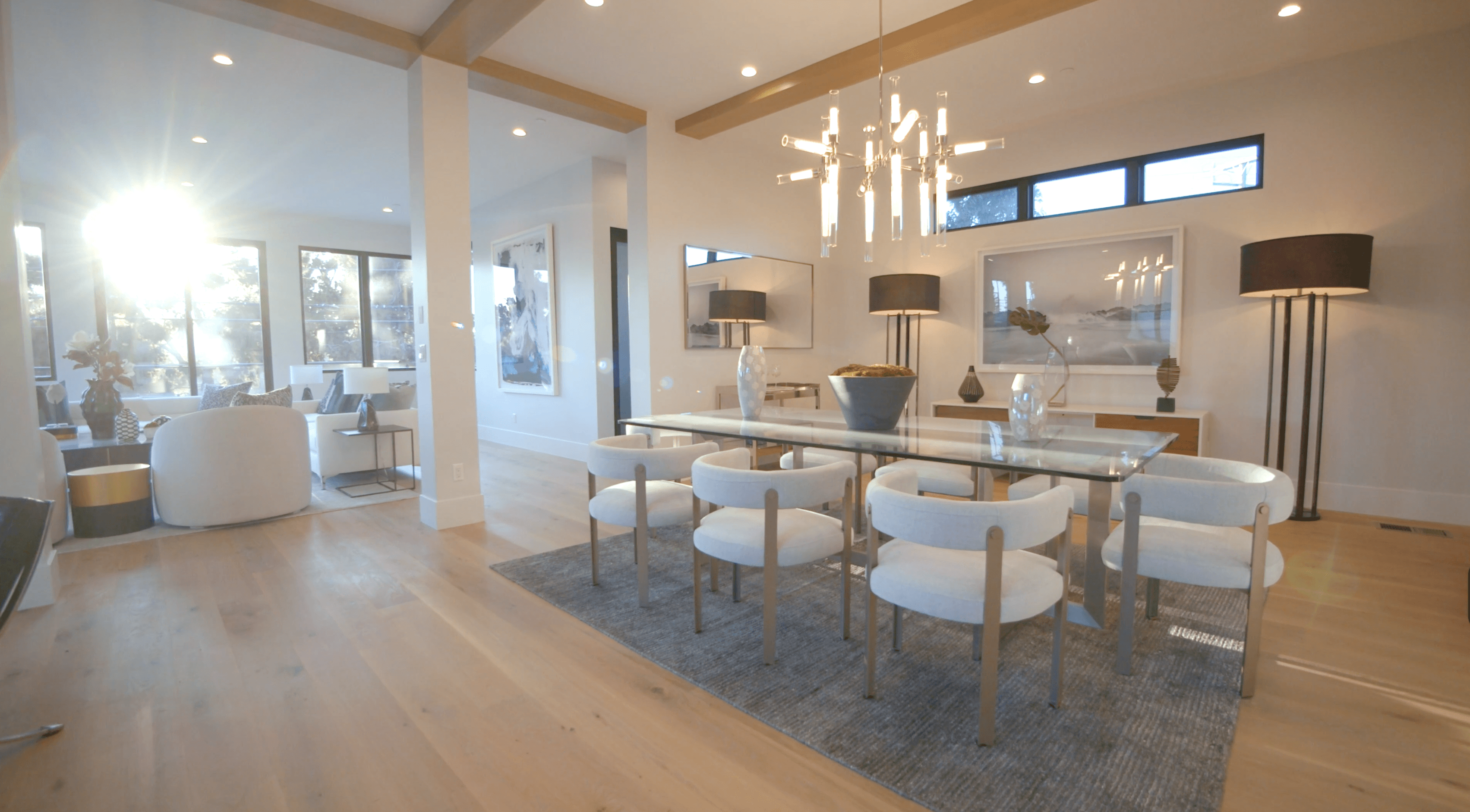 Bright modern dining area with white furniture, wooden beams, and a cozy atmosphere.