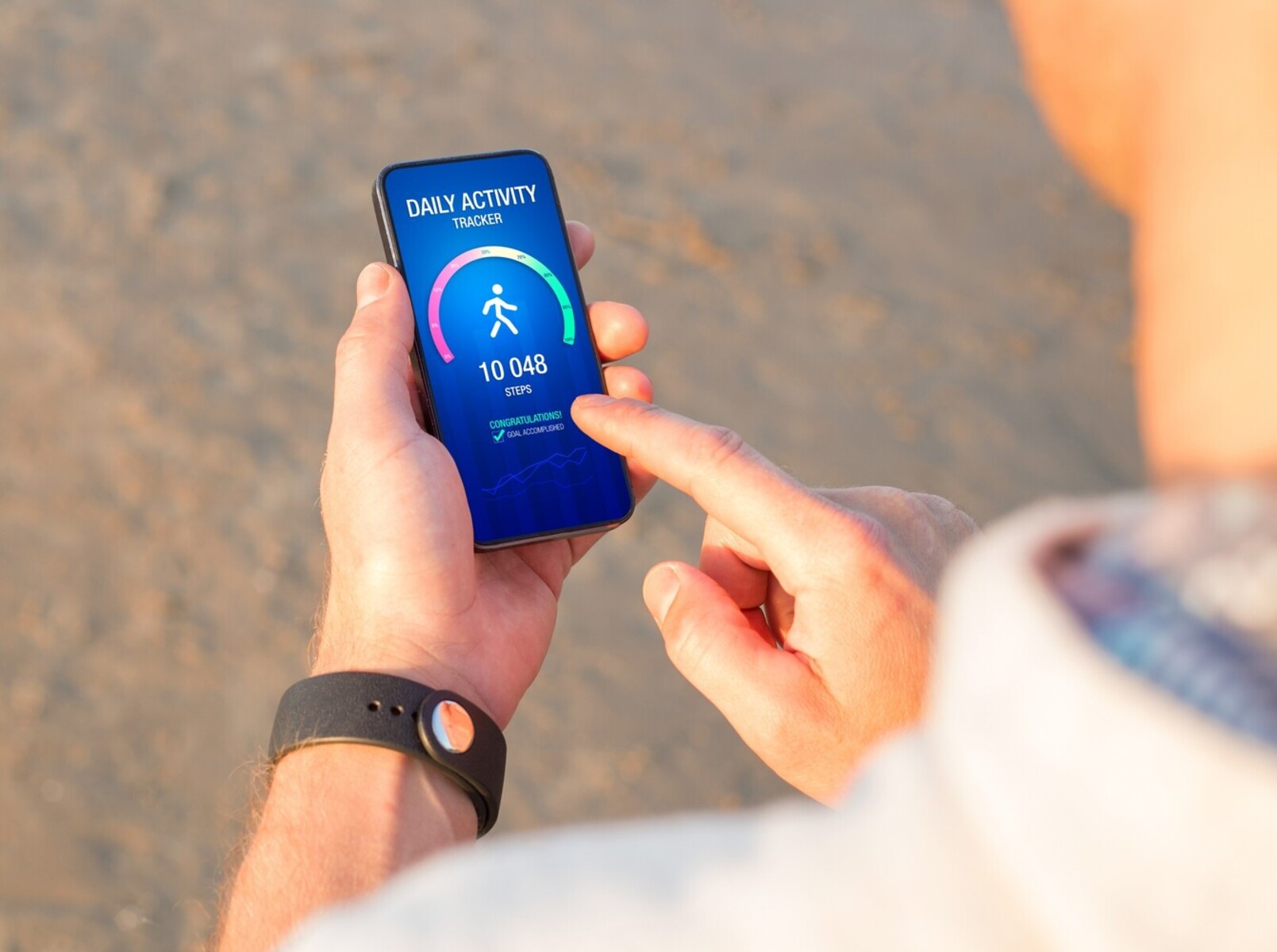 a man checking his fitness app to see that he has met his goal of how many steps to walk to lose weight