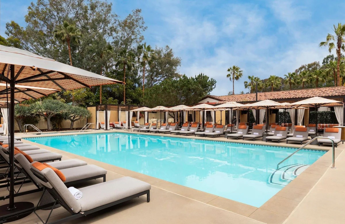 Table with open book, tea and pillows spread around