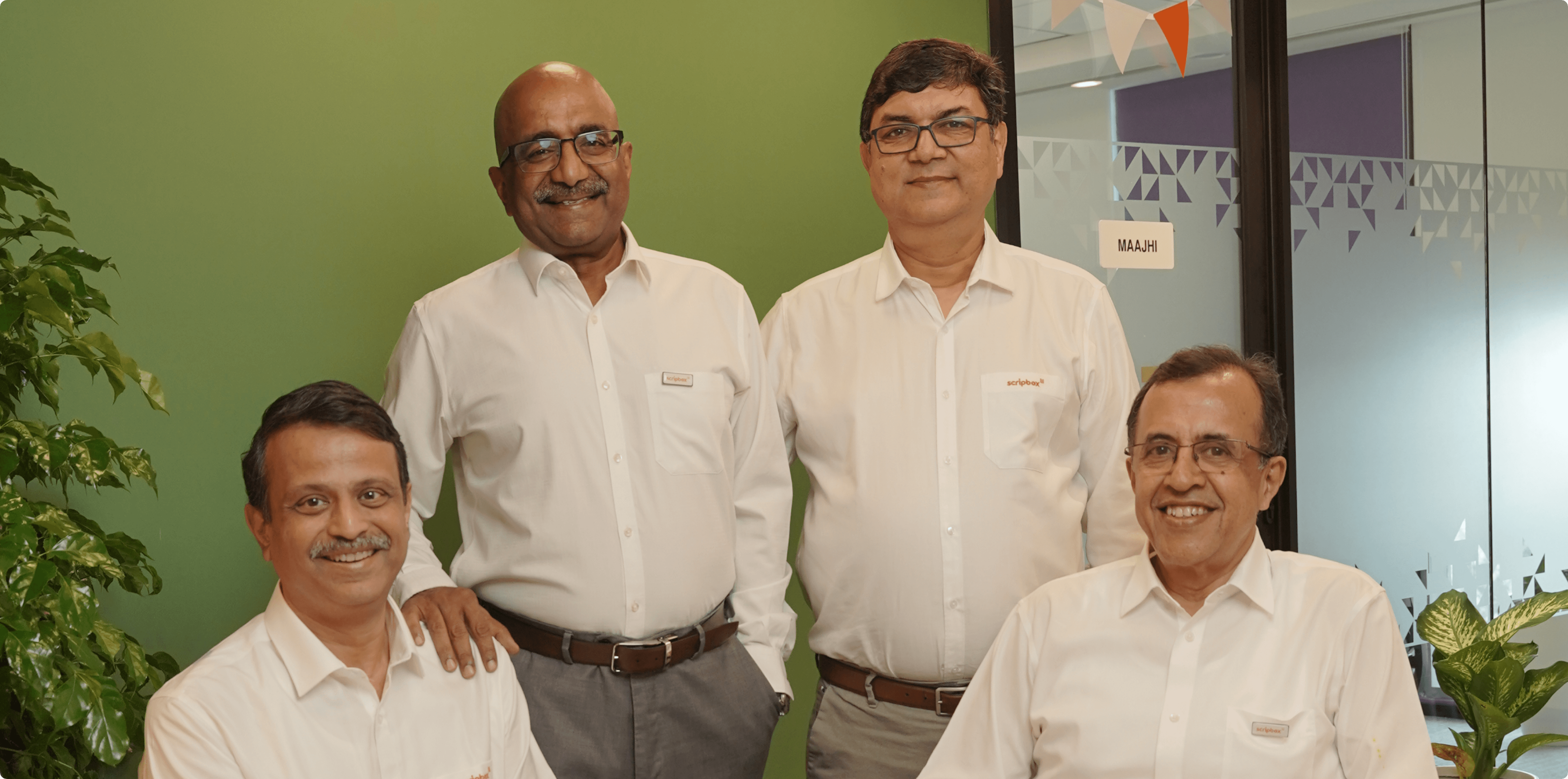 Group portrait of the Wealth Managers founders in an office setting.