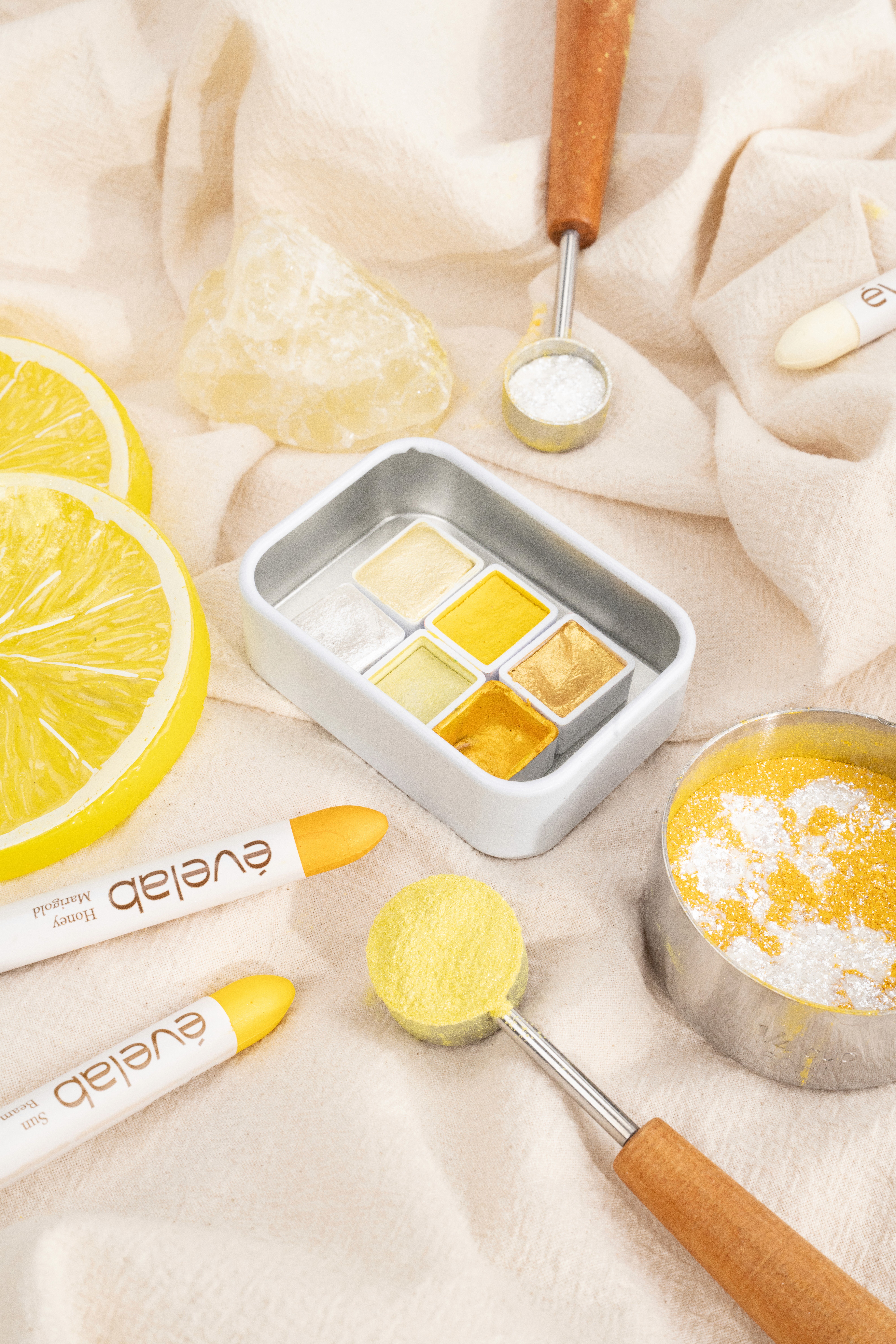 Wooden outdoor table set with multiple plates of food, including dips, salads, potatoes with cheese, and glasses of water, with hands reaching in to eat.