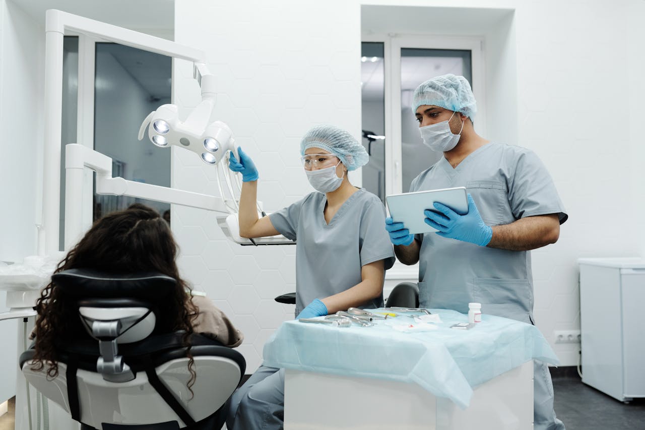 Dental assistant helping dental hygienist