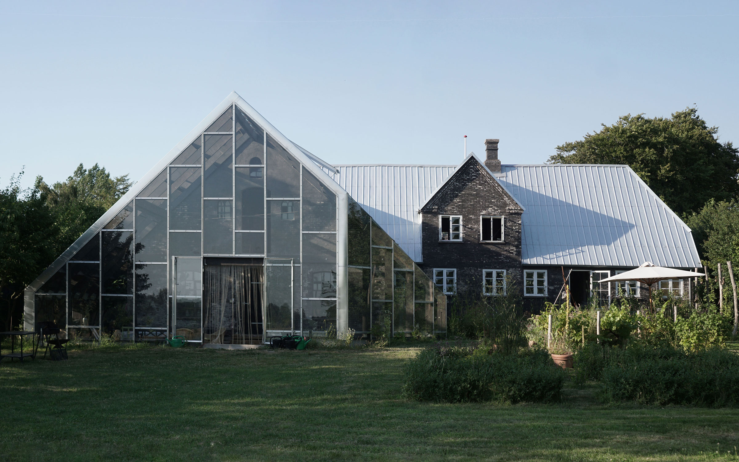 Bakkely Orangery glass extension integrated with existing house and garden on Ærø by Asger Risborg Jakobsen