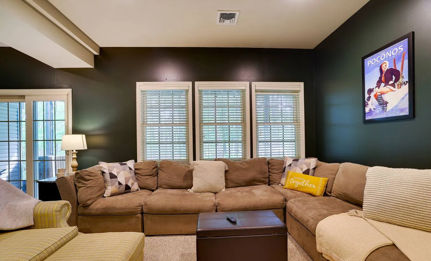 Lower living room with oversized tan sectional and navy accent wall at Pop's Place
