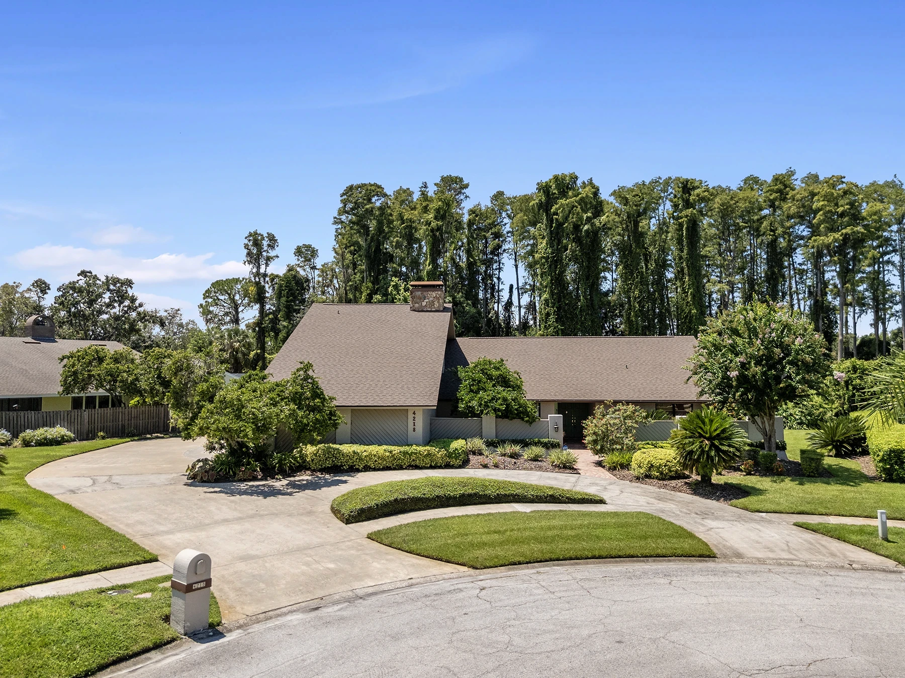 Front exterior of a custom Carrollwood Village home with circular driveway and landscaped yard