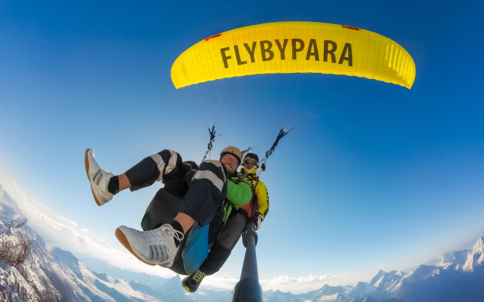 Matterhorn पर्वत के ऊपर साफ आसमान के साथ पर्यटक पैराग्लाइडिंग कर रहे हैं, गाइड के साथ।