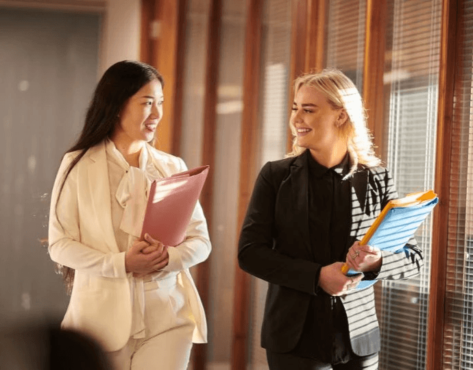 Two professional women in conversation, representing top accountant CPAs for corporate law firms in the USA.