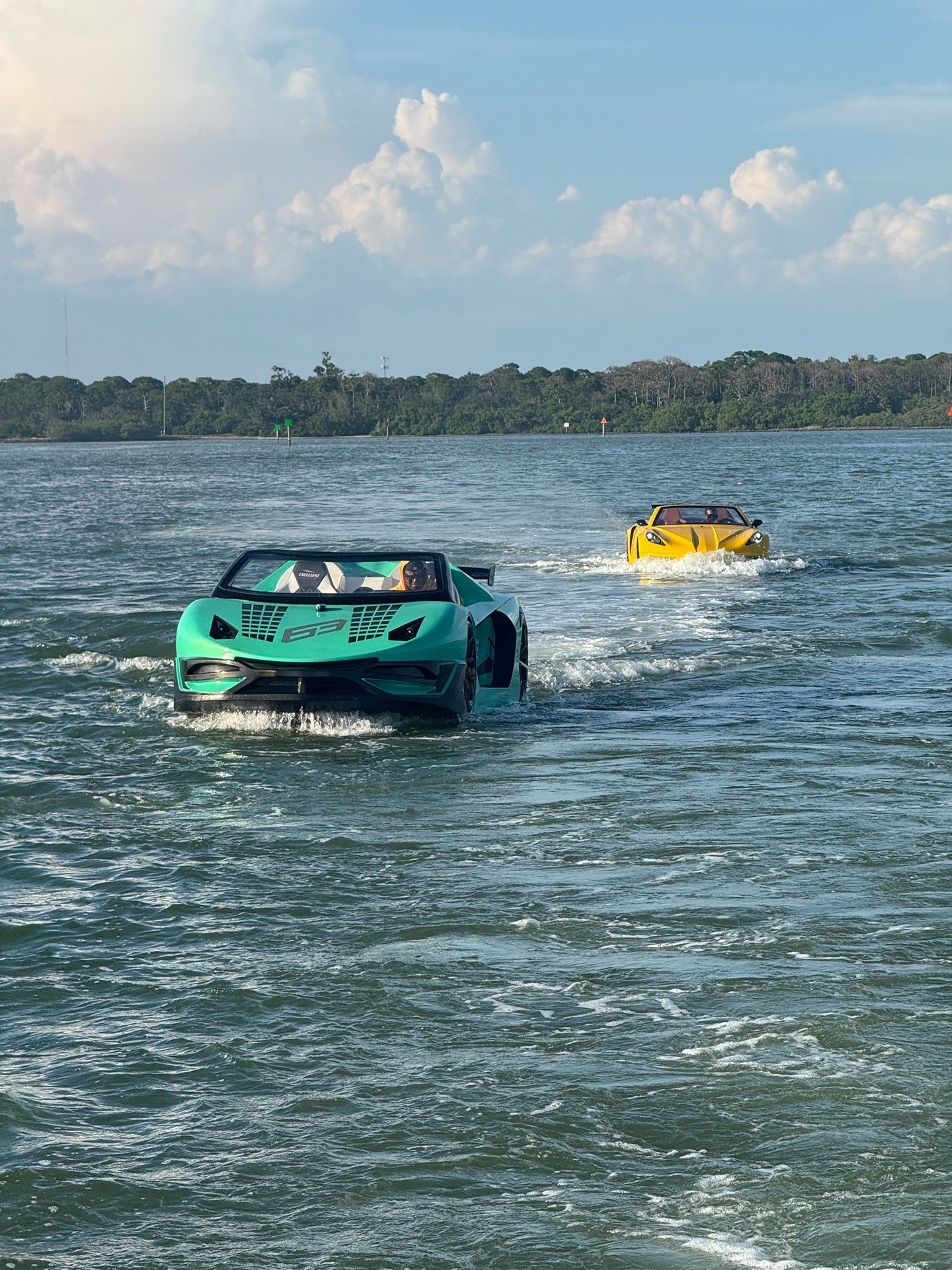 A group of six people gather around a wooden table where an older man in an apron kneads dough