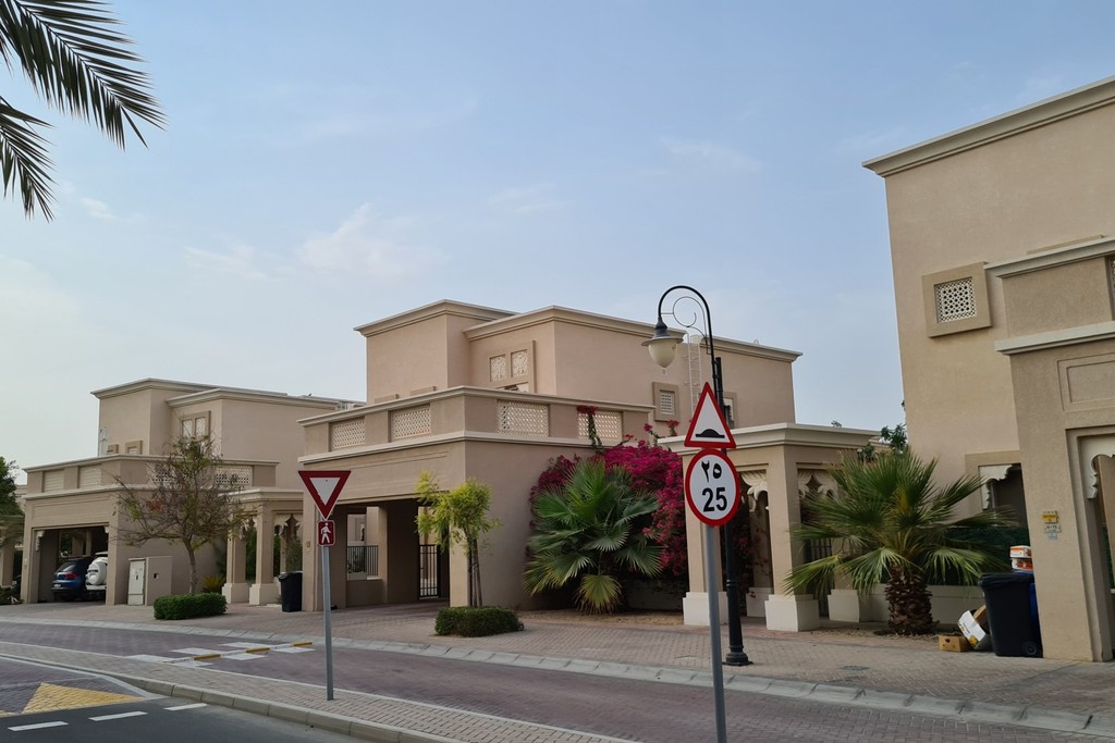 A scenic palm tree row borders the road to Cedre Villas, Dubai Silicon Oasis.