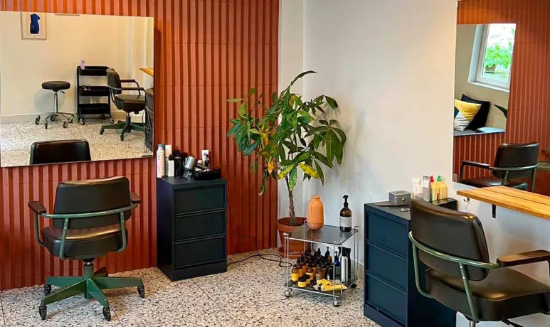 A green butterfly rests on a flower.