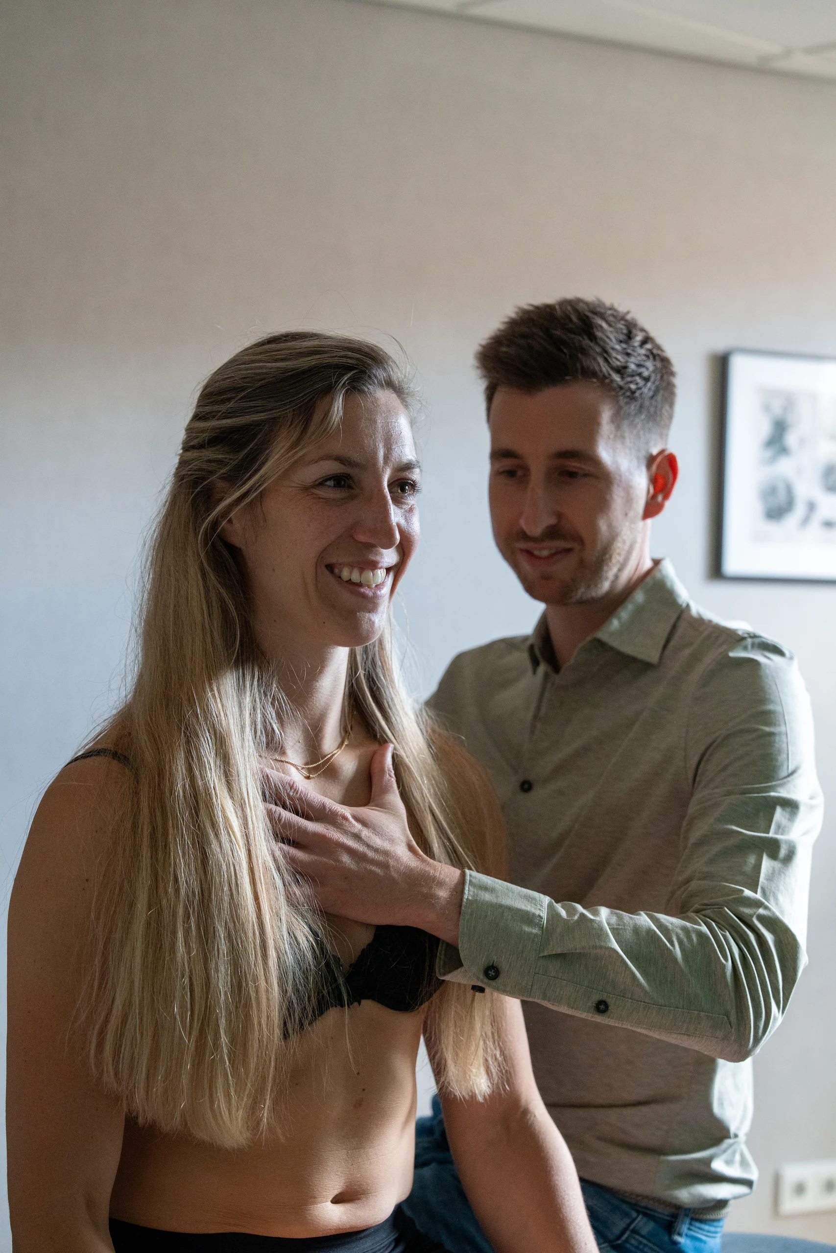 Osteopaat onderzoekt de schouder van een staande patiënt