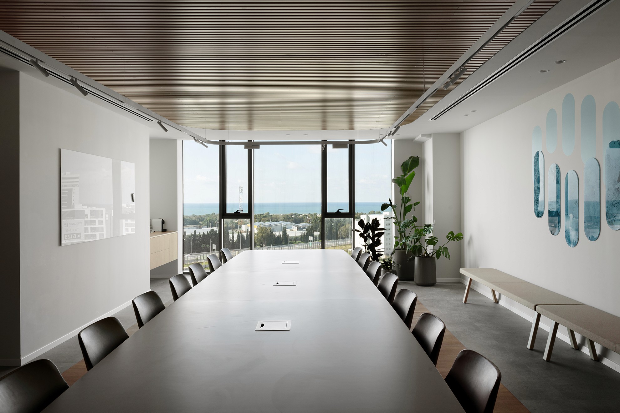 אומנות במשרד: קיר כוח בחדר הישיבות עם יצירת אומנות אבסטרקטית (Blue Ovals) בגווני המותג, המוסיפה עומק וצבע לחלל.