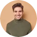 Smiling young man in a green sweater against a light orange background, framed in a circular crop.